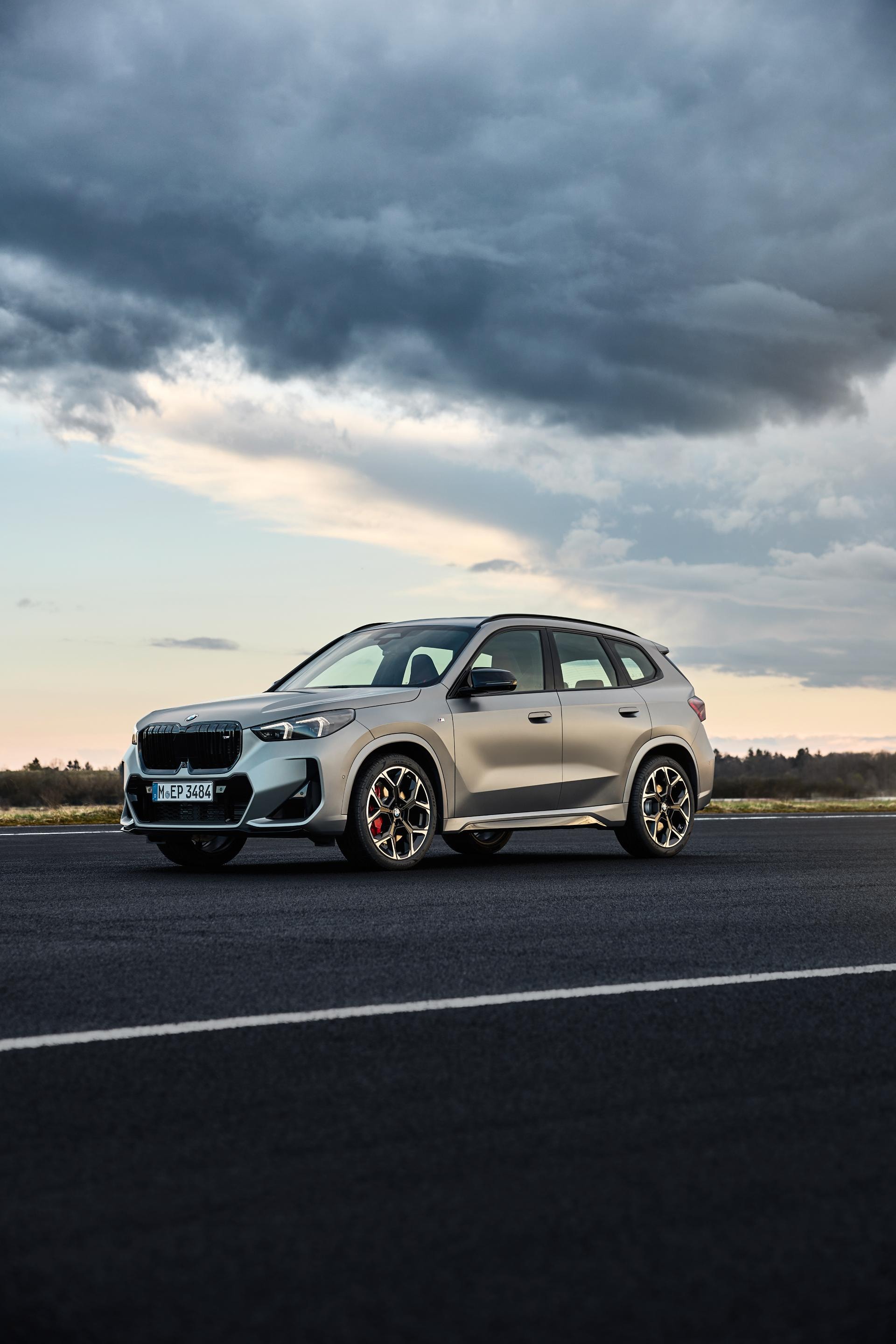Perfil lateral del BMW X1 Híbrido bajo un cielo nublado, enfatizando su línea deportiva.