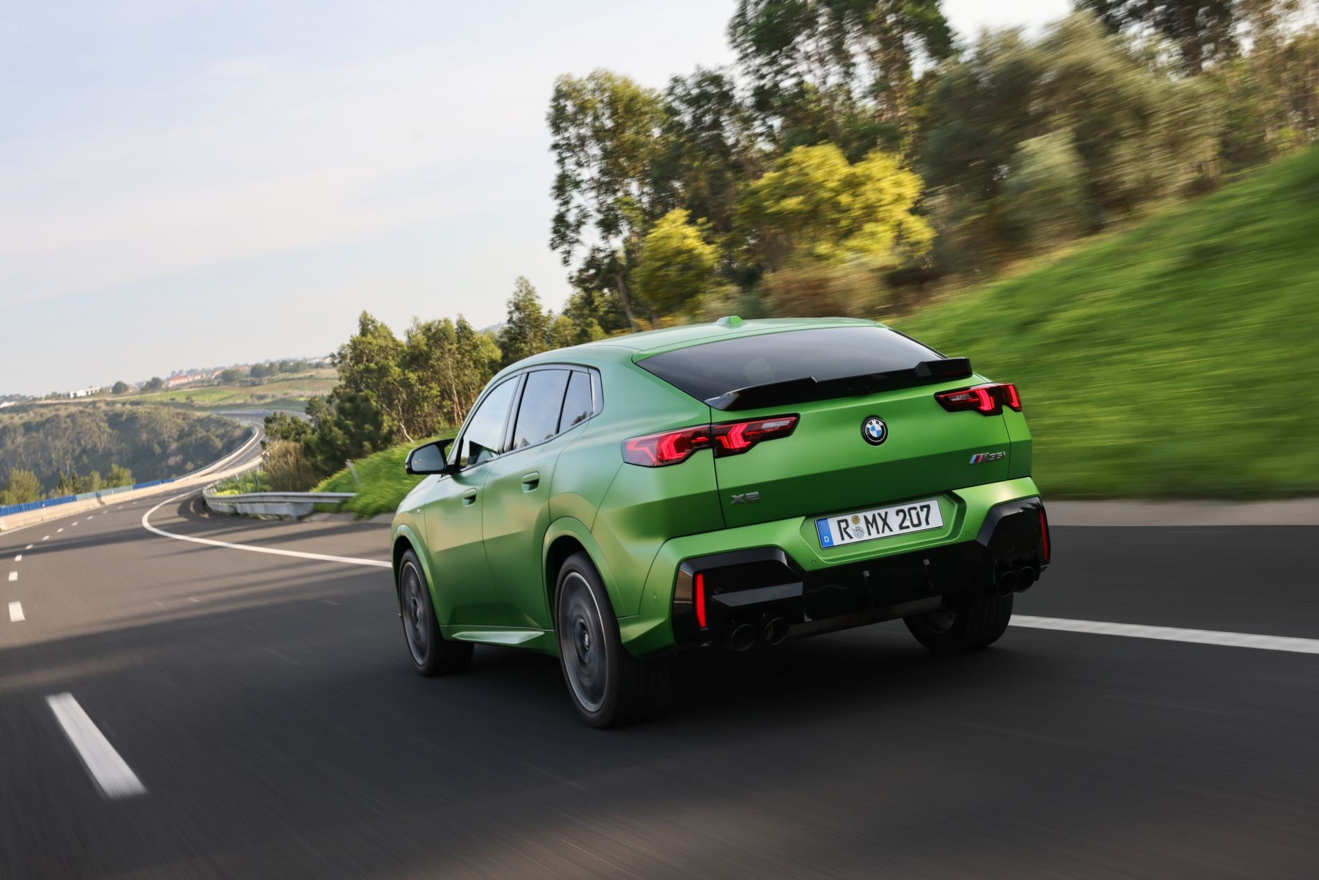 BMW X2 detenido en una playa, exhibiendo su diseño deportivo.