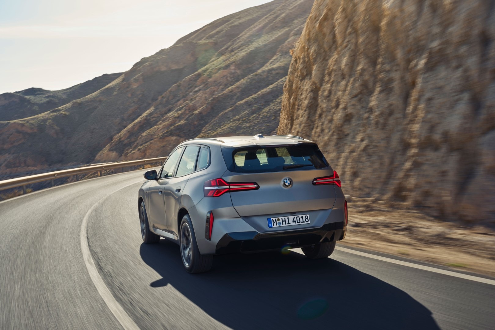 Vista dinámica del BMW X3 por carretera, destacando su diseño trasero y lateral.