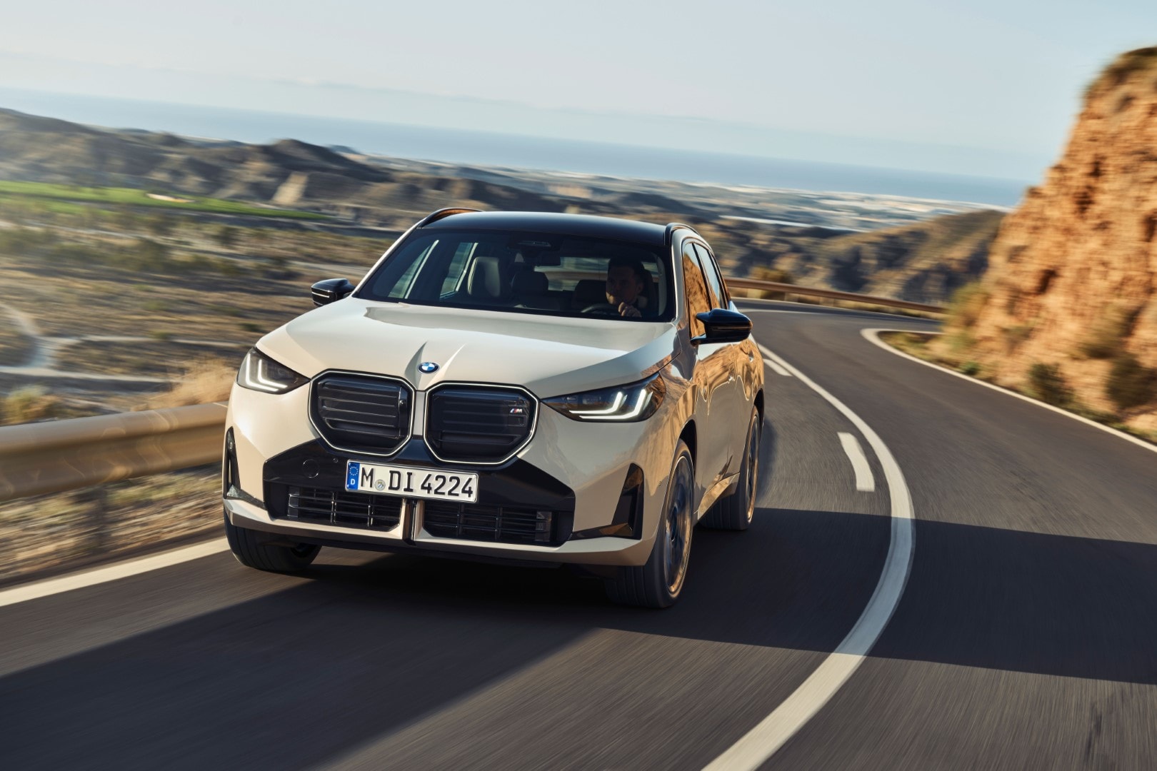 Vista lateral del BMW X3 en carretera, subrayando su desempeño y línea.