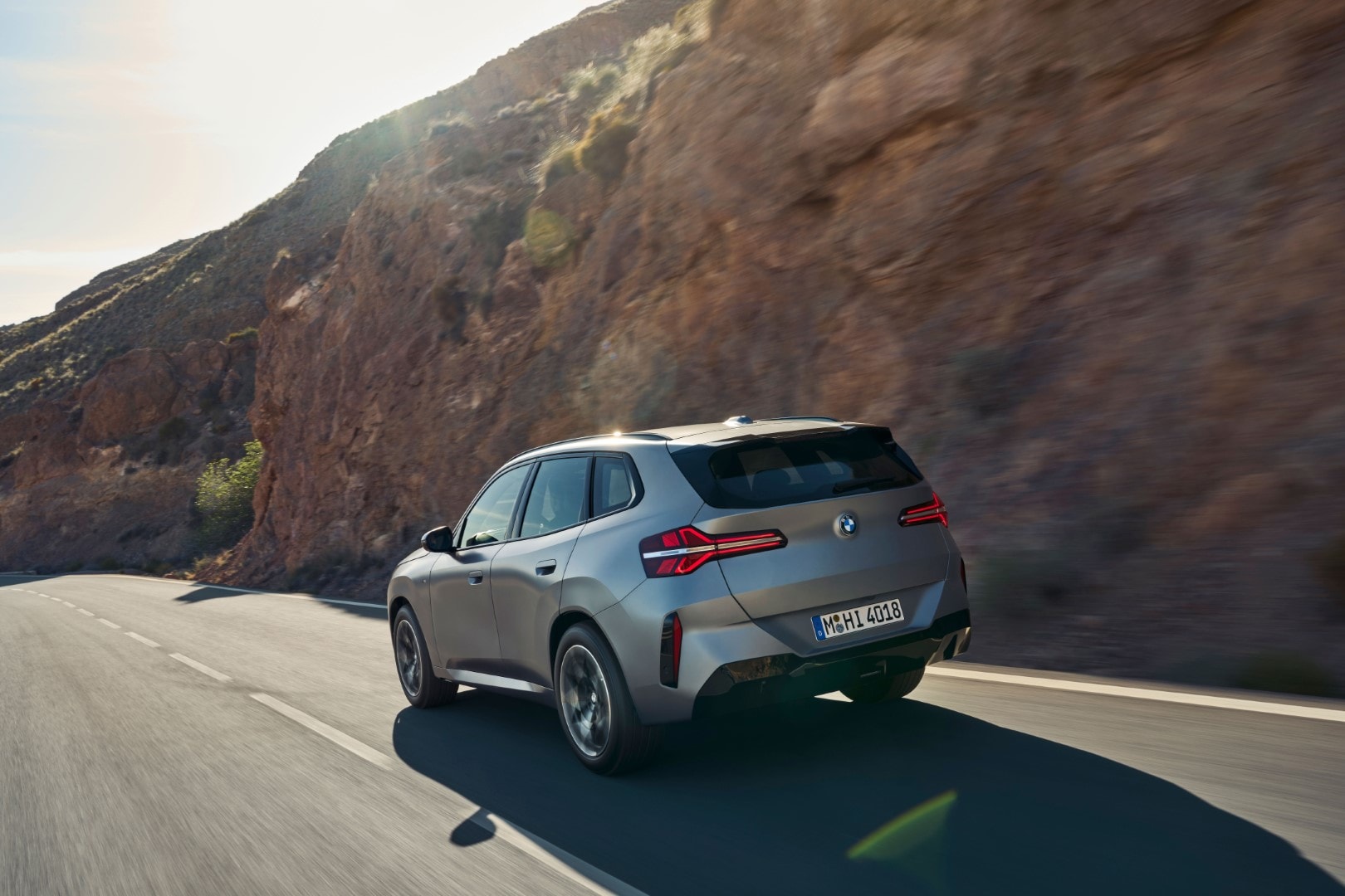 Vista trasera del BMW X3 en ruta, destacando su diseño y escape.