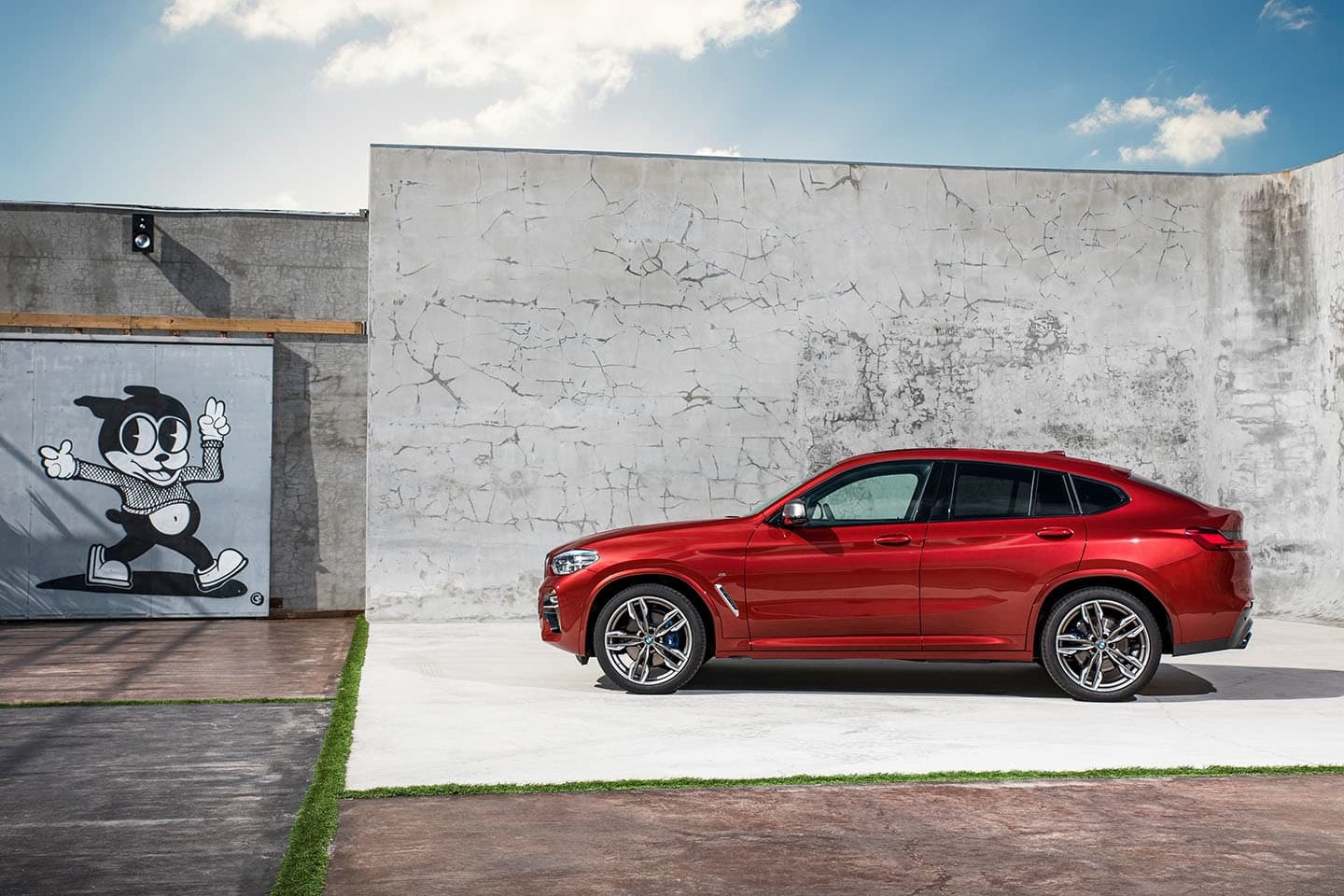 Vista lateral del BMW X4 realzando su línea coupé y llantas elegantes.