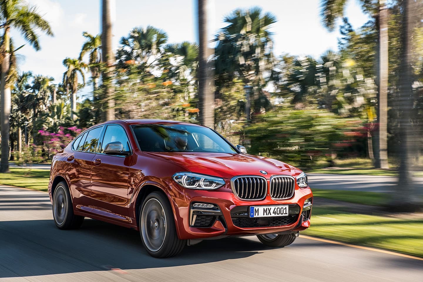Toma frontal del BMW X4 en plena conducción, destacando su parrilla.