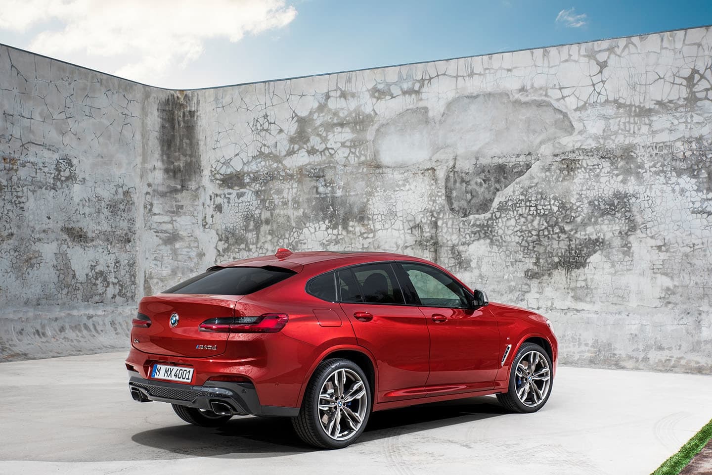 Vista trasera y lateral de un BMW X4 en color rojo.