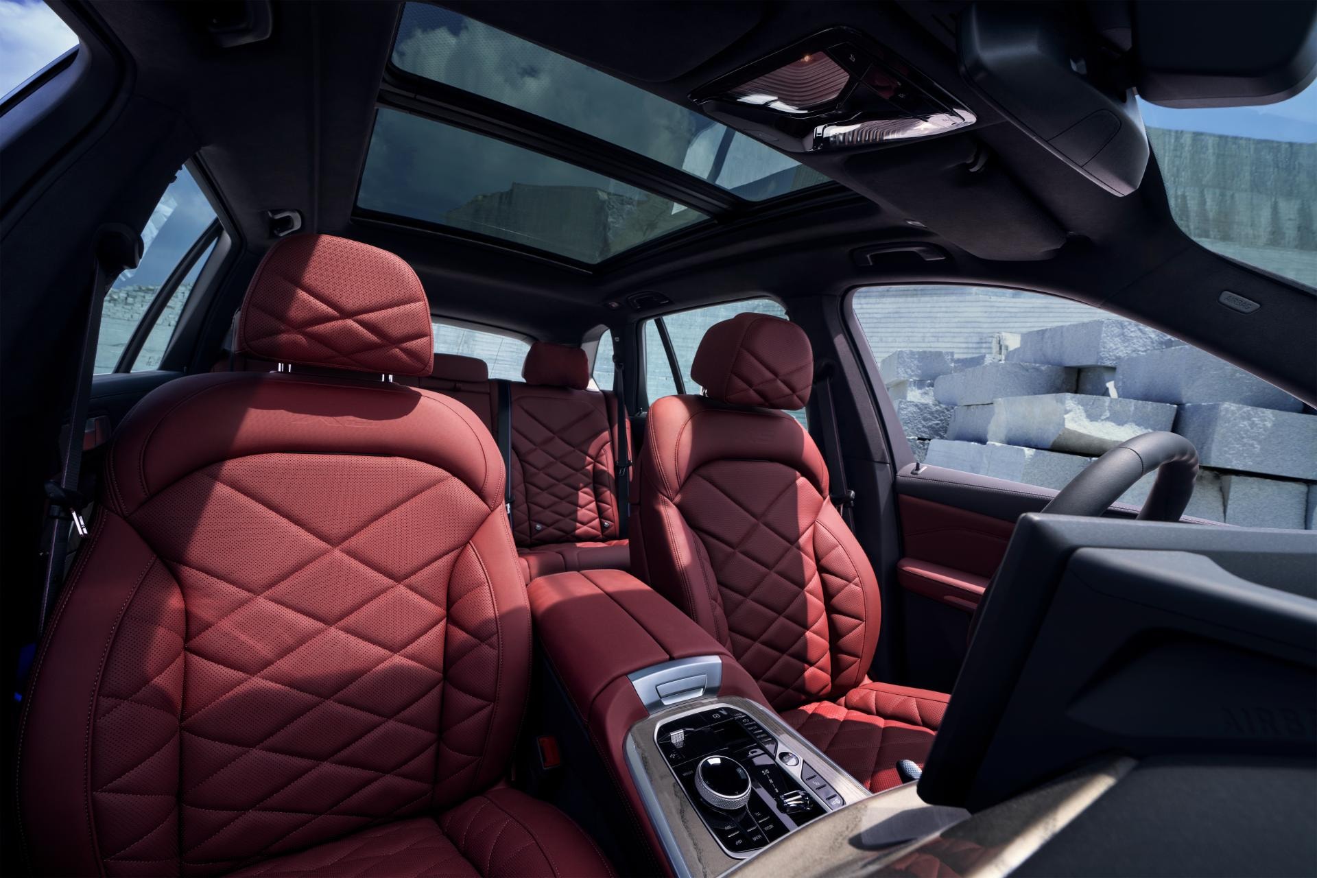 Interior del BMW X5 Híbrido con asientos de cuero rojo y techo panorámico.