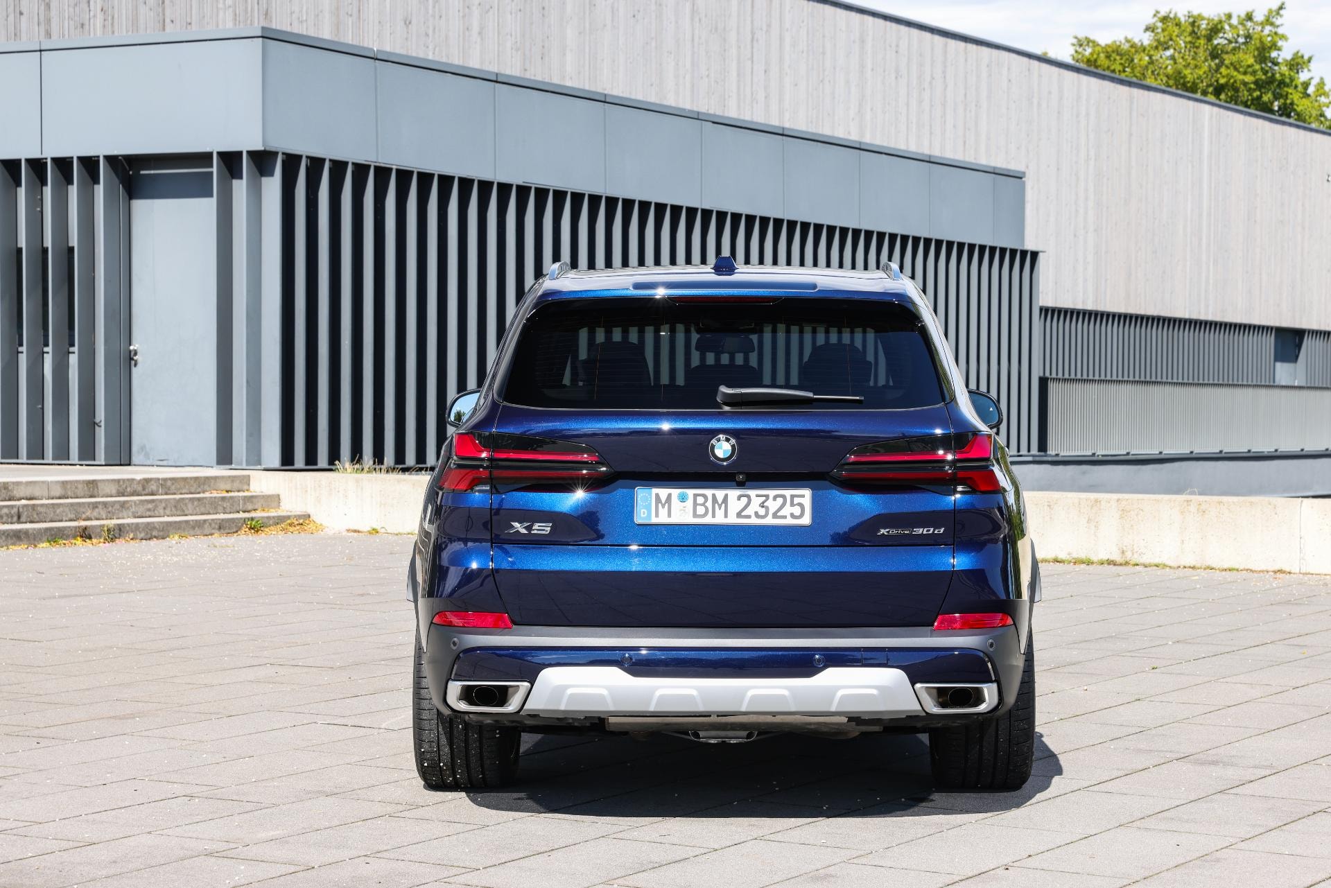 Vista estática de la parte trasera del BMW X5 Híbrido en un entorno urbano.