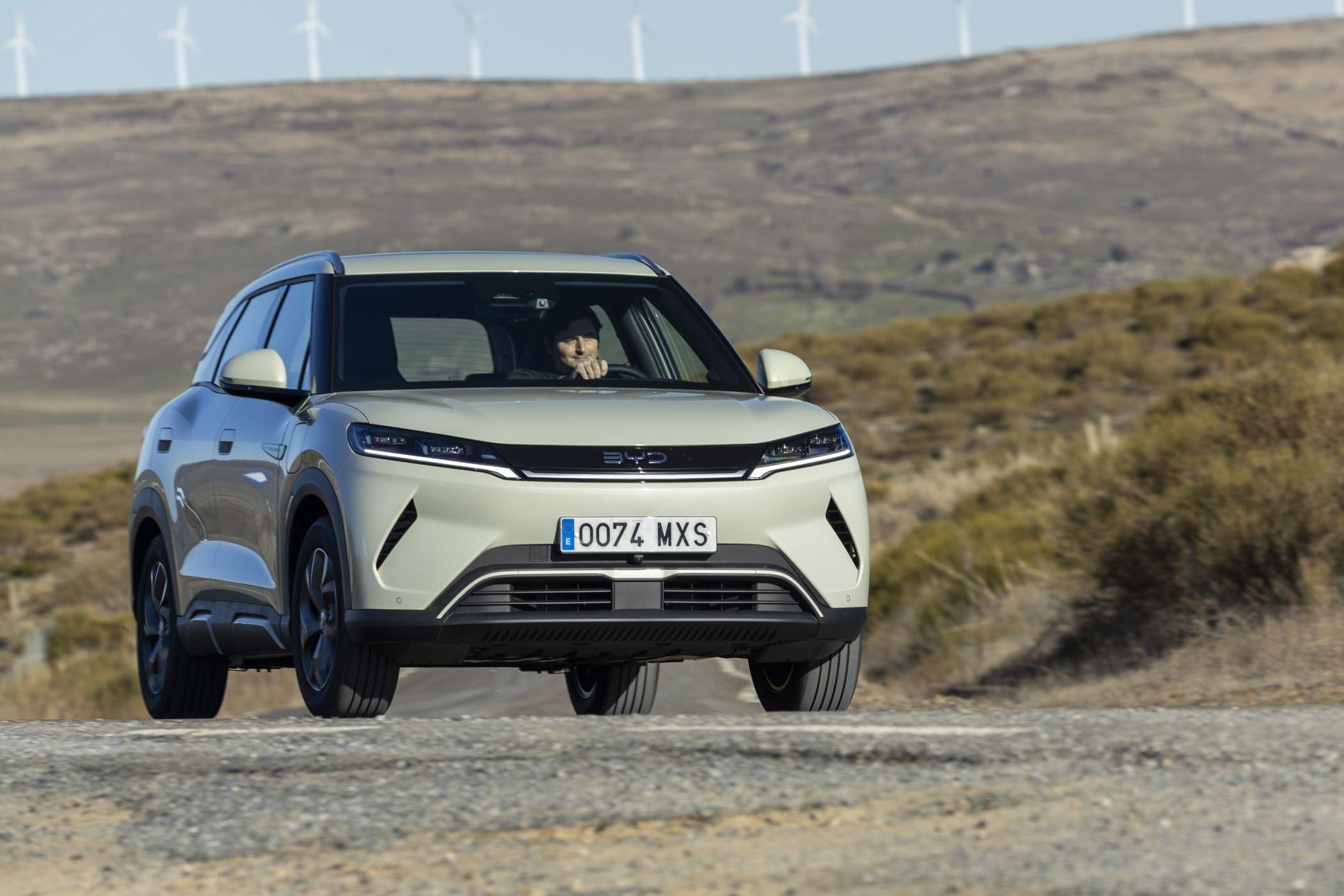 BYD Atto 2 en movimiento por un paisaje natural, resalta su diseño aerodinámico.