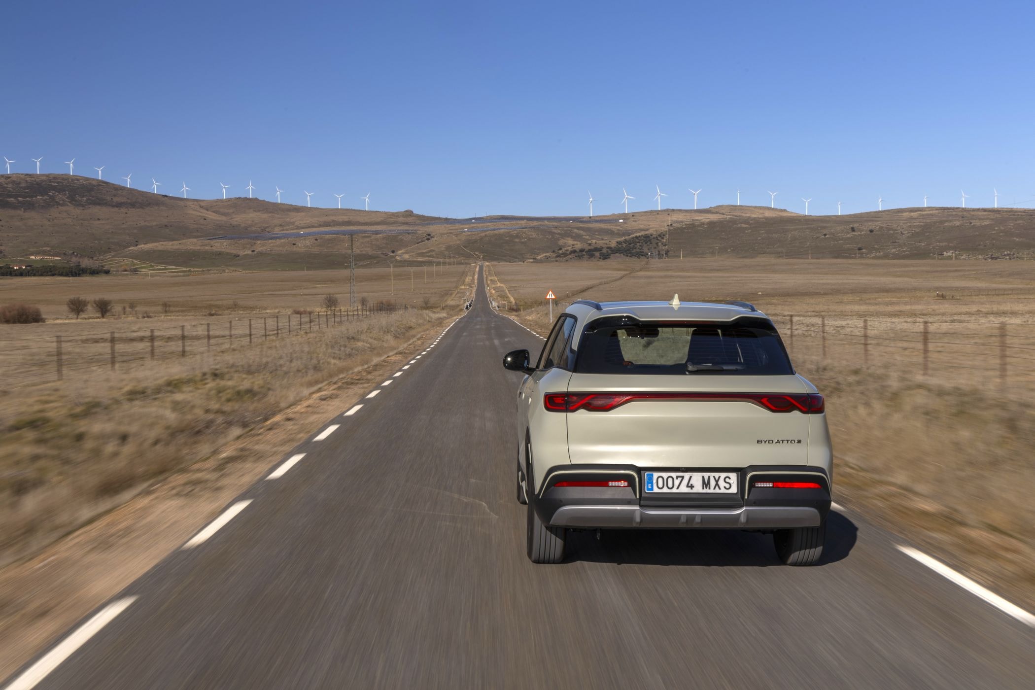 El BYD Atto 2 avanza por la carretera con un fondo urbano moderno.