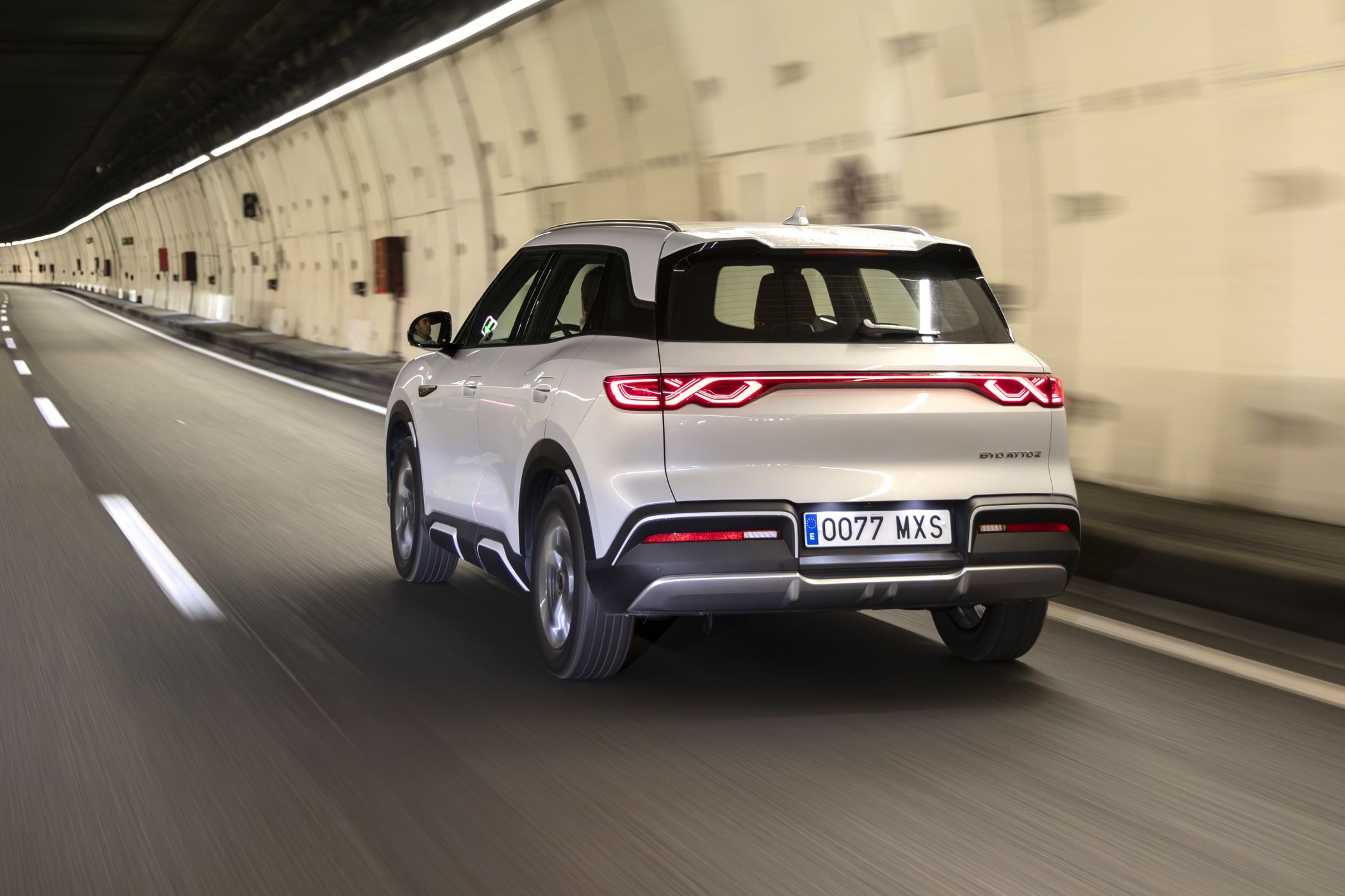 El BYD Atto 2 avanzado por la carretera, con un espejo reflejando el agua.