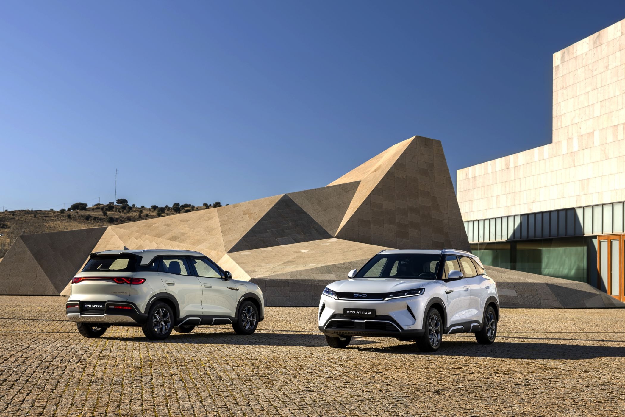 Dos unidades del BYD Atto 2 en un entorno arquitectónico moderno.