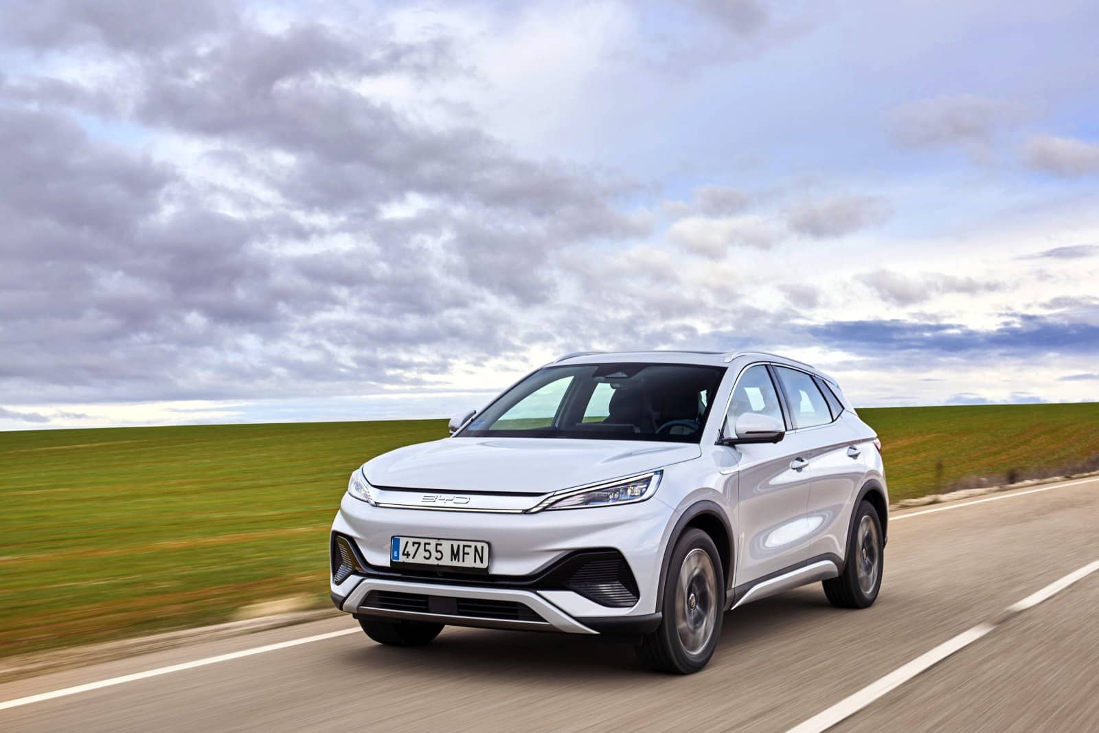 El Atto3 circula con cielo nublado, ofreciendo una vista completa lateral y del techo.