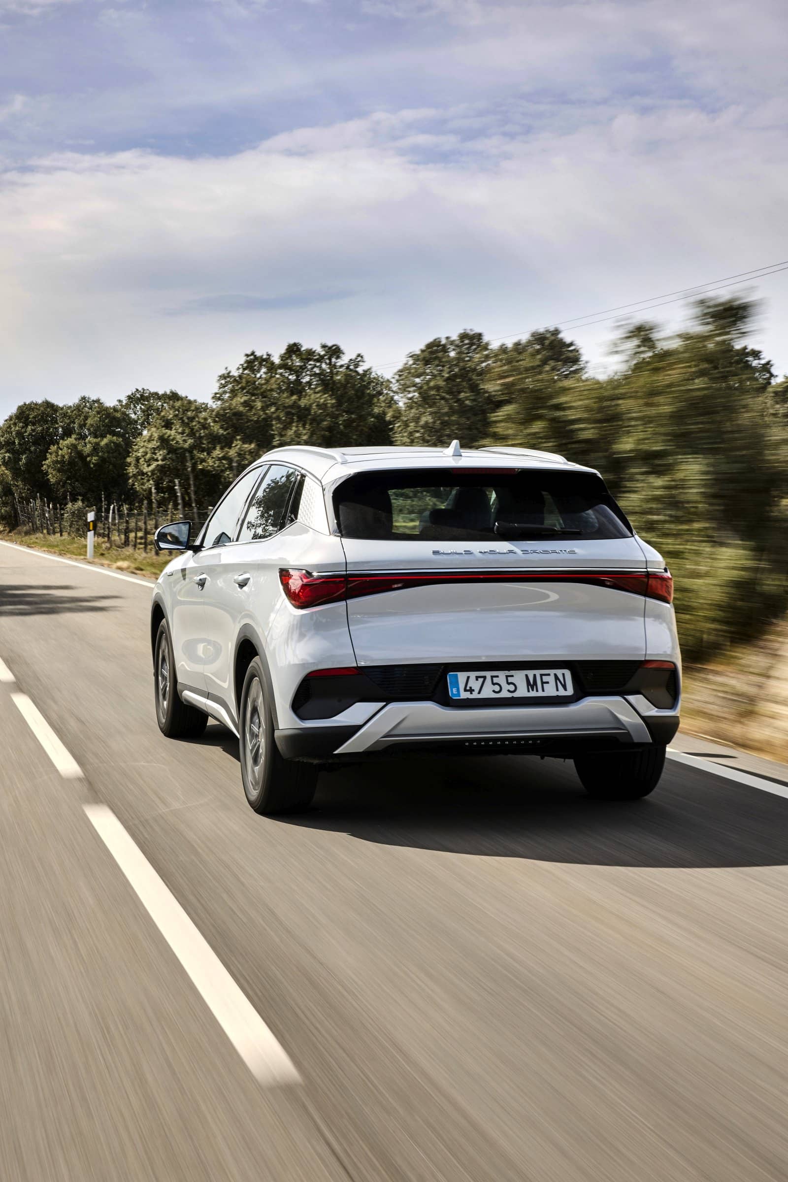 Perspectiva dinámica de la trasera del BYD Atto3 en carretera.