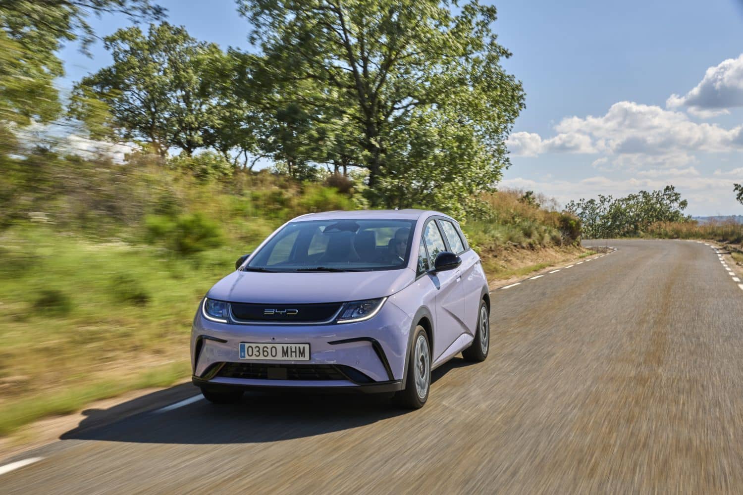 Ángulo frontal del BYD Dolphin con un entorno campestre, destacando su diseño urbano