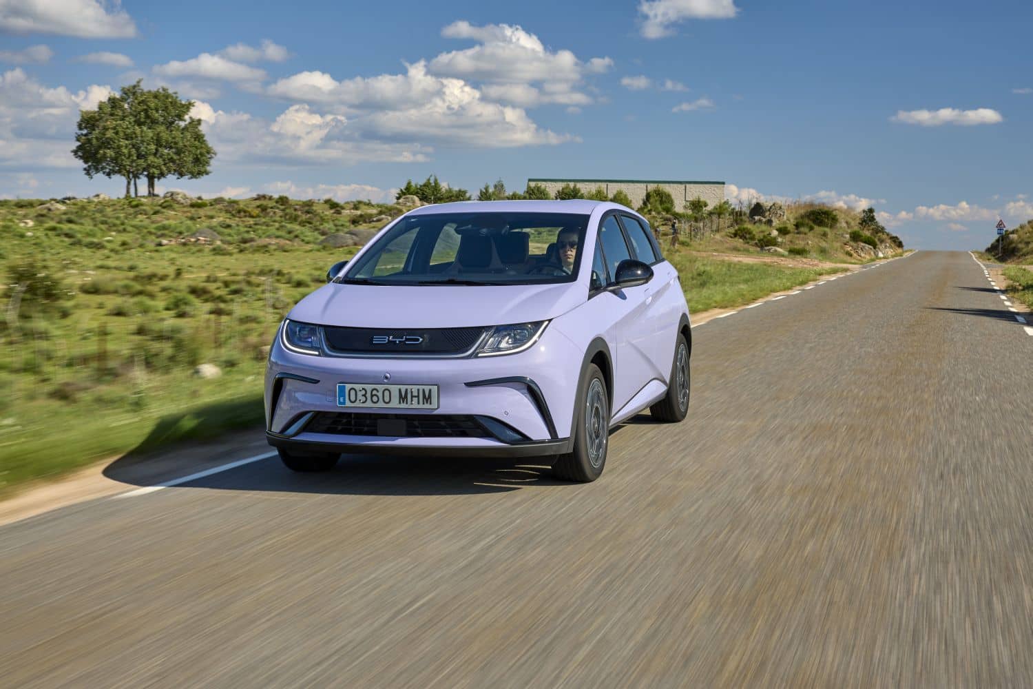 Vista lateral del BYD Dolphin rodando por la carretera, subrayando su silueta limpia