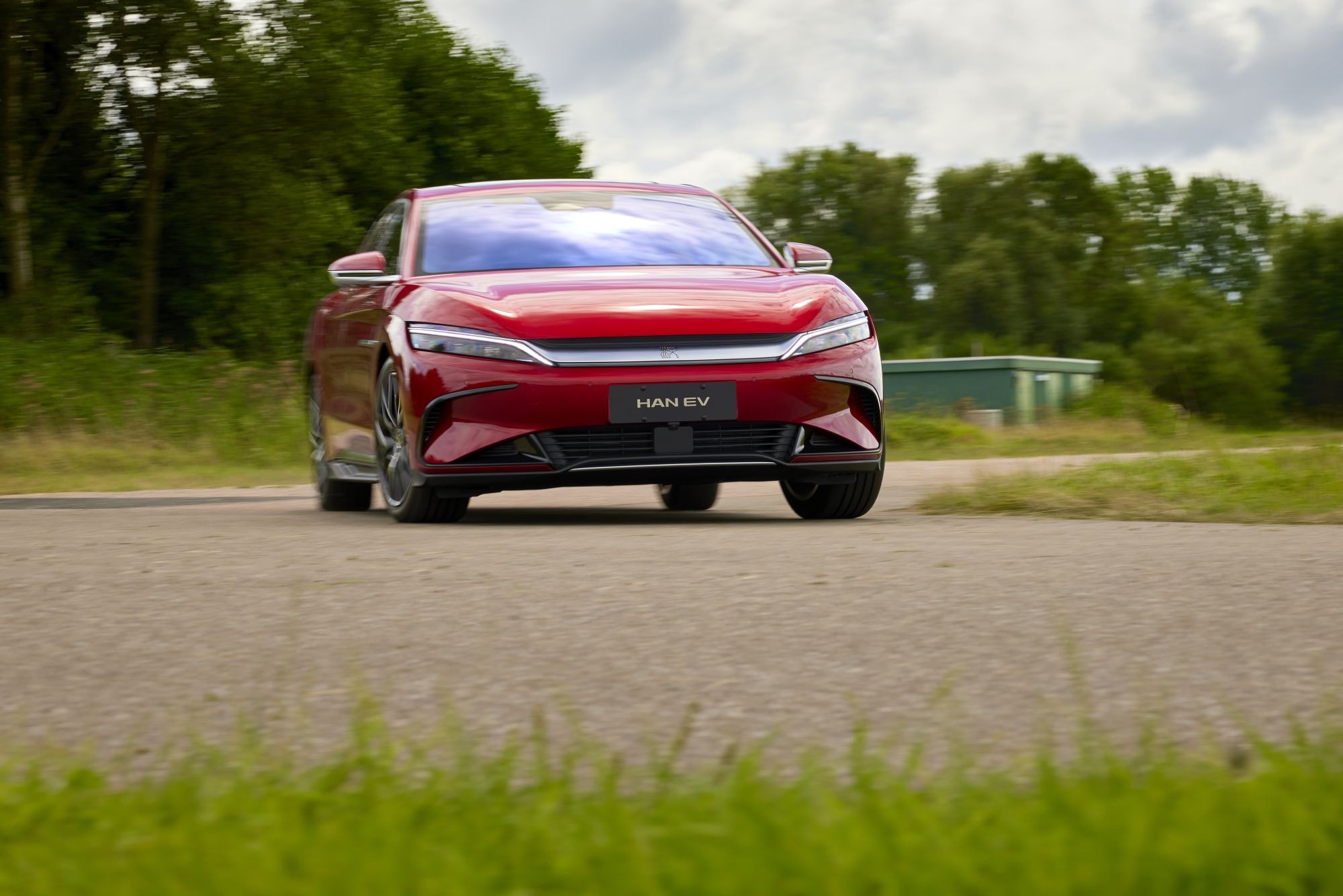 BYD Han en color azul, mostrando sus líneas elegantes frente a un edificio.