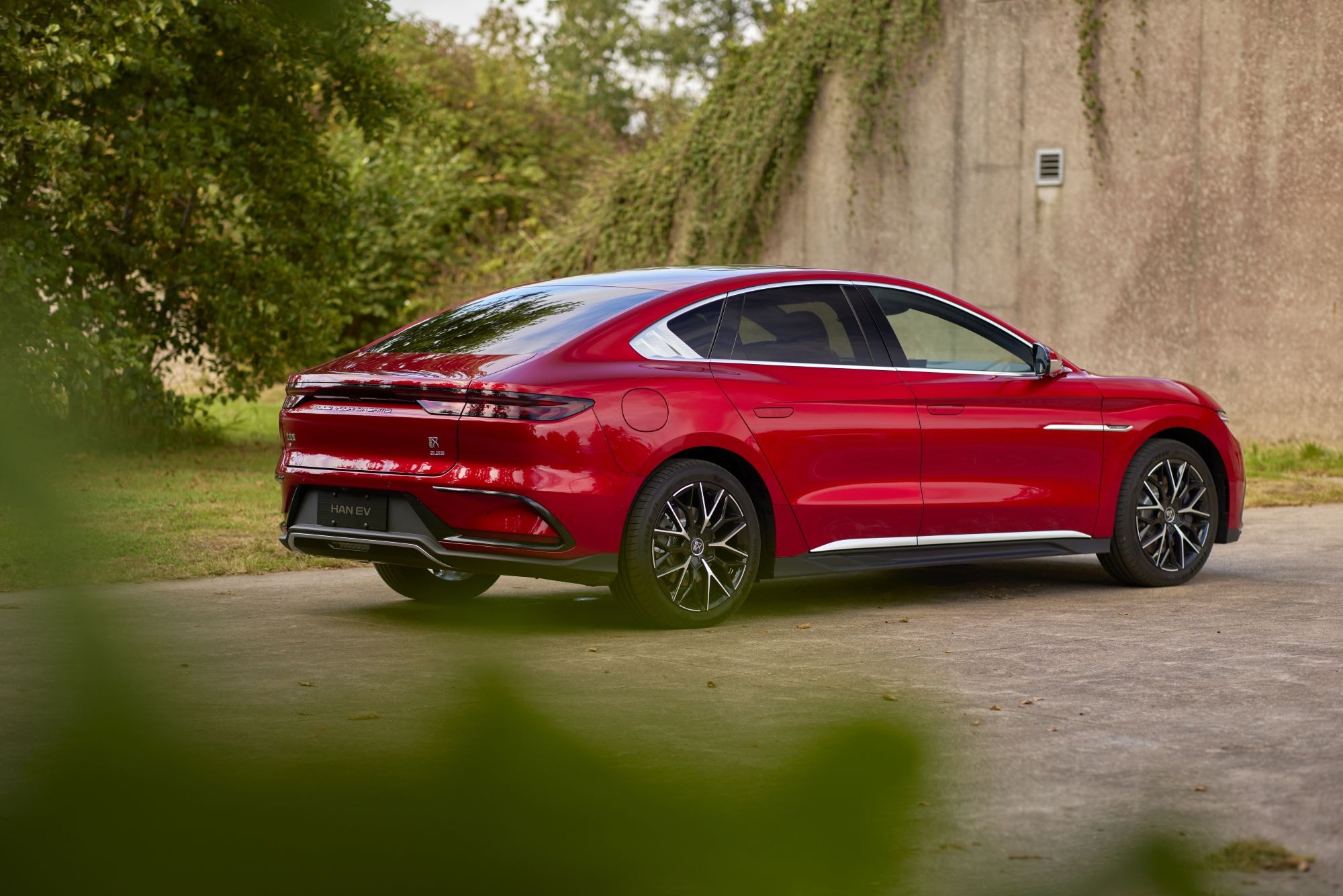 Perspectiva lateral del BYD Han rojo, mostrando sus líneas elegantes.