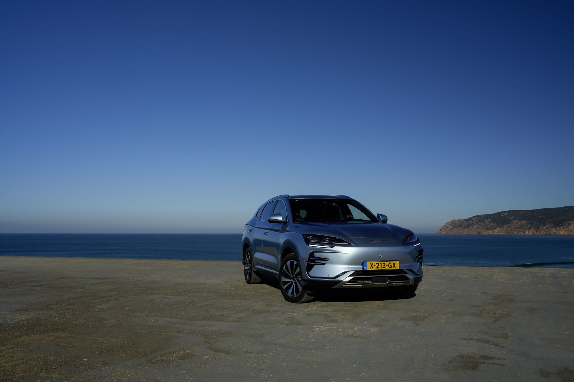 BYD Seal U recorriendo una carretera costera al atardecer.