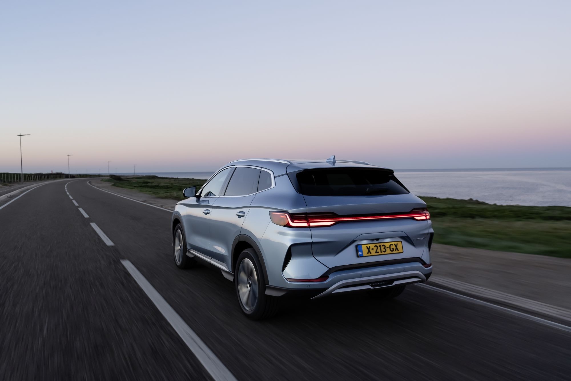 Vista posterior del BYD Seal U junto a la costa, destacando sus luces elegantes.