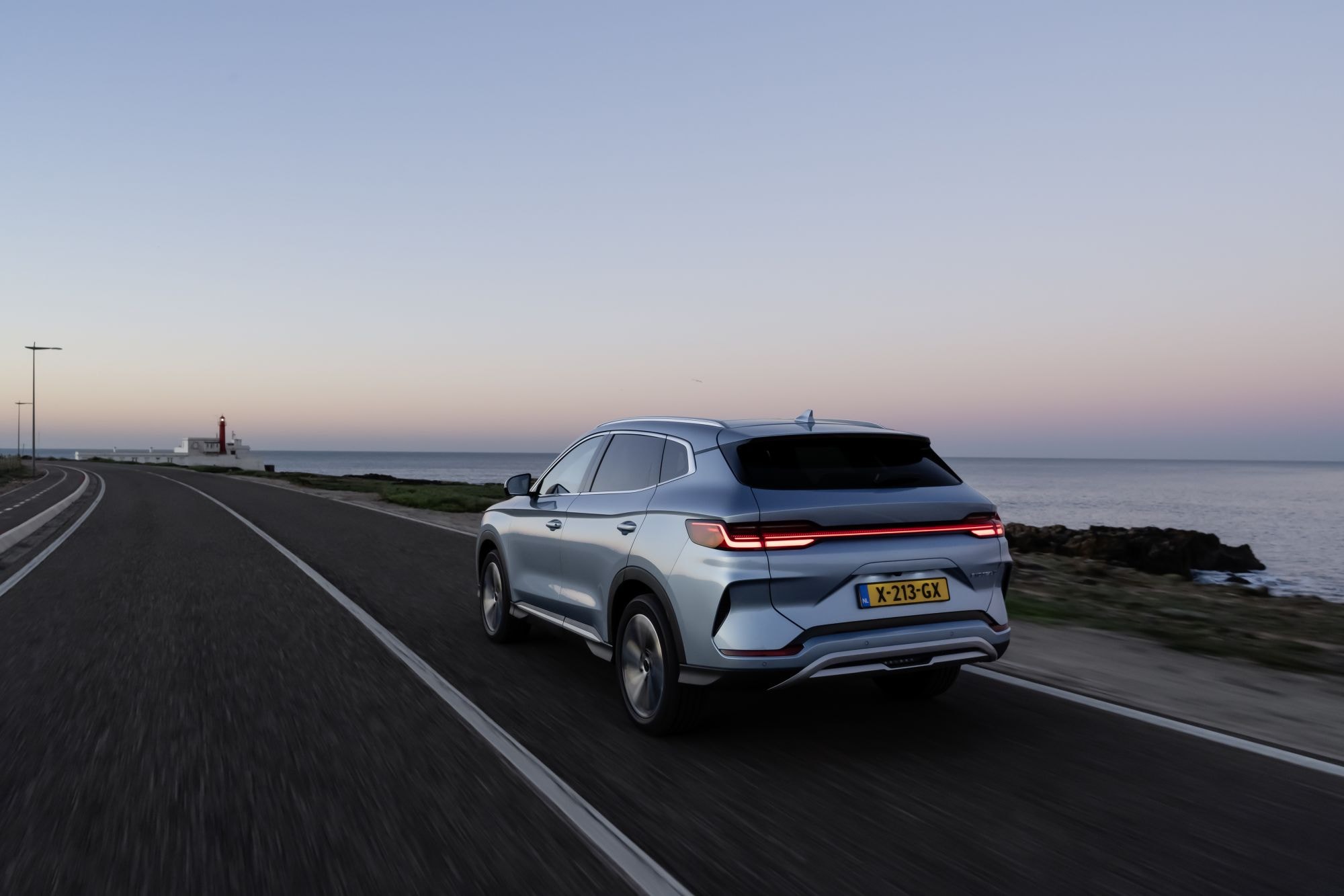 Vista trasera del BYD Seal U en una carretera junto al mar, mostrando su diseño distintivo.