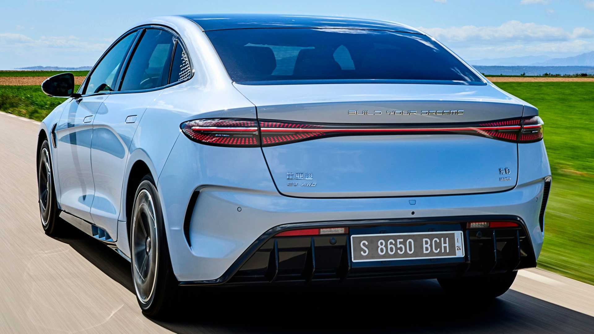 Vista trasera del BYD Seal en movimiento, exhibiendo su firma luminosa distintiva.