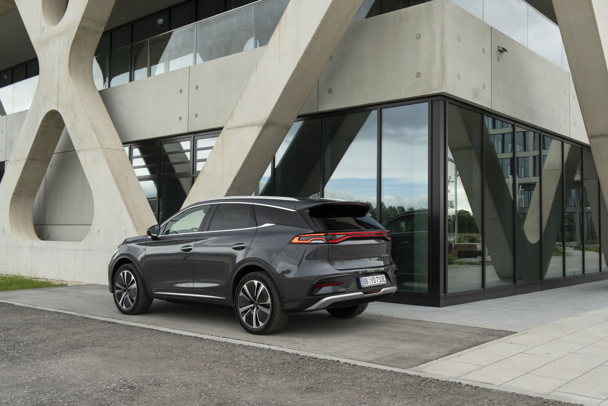 BYD Tang eléctrico frente a una moderna arquitectura, simbolizando innovación.