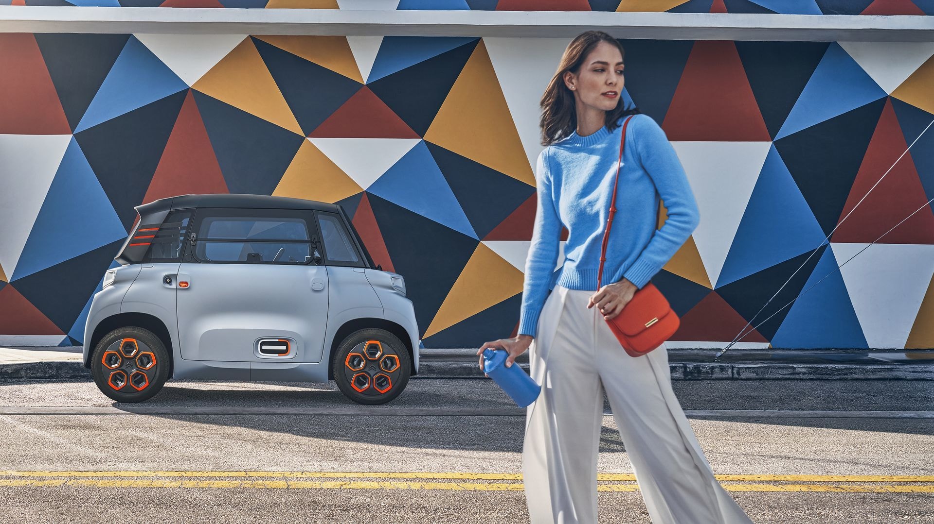 Imagen promocional del Citroën AMI con una mujer caminando hacia él.