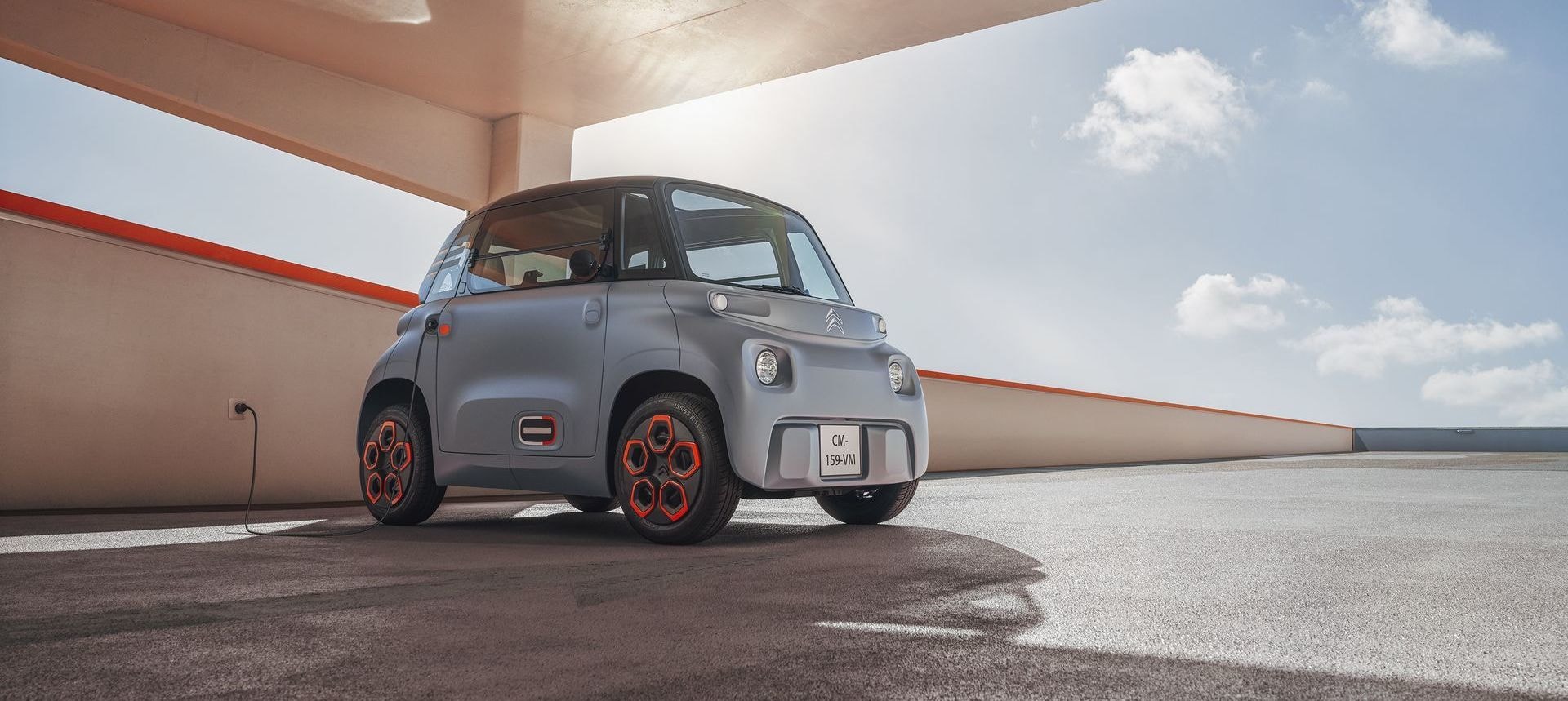 Citroën AMI estacionado, mostrando su frontal y perfil lateral en un ambiente urbano.