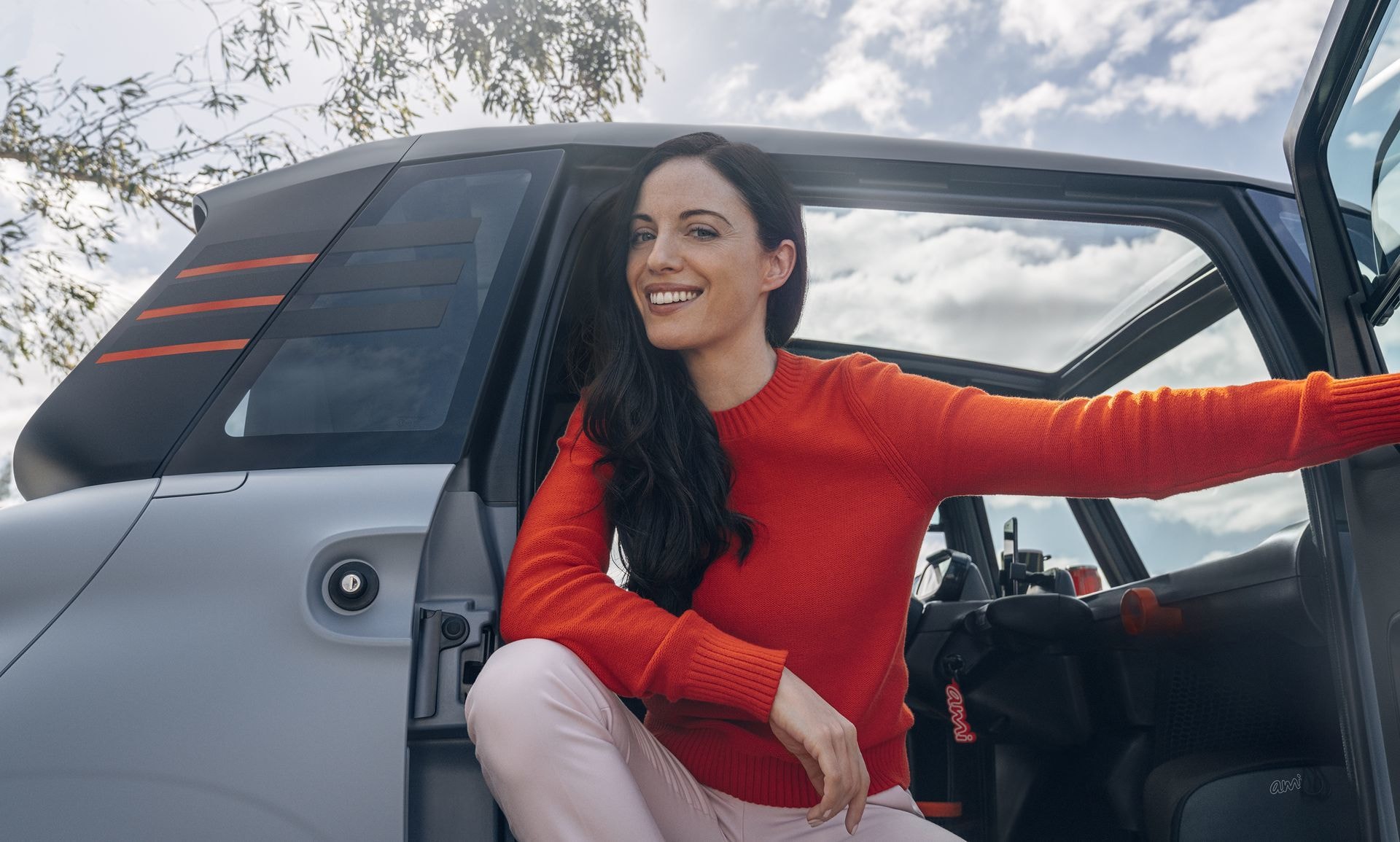 Una mujer sentada en el Citroën AMI con la puerta abierta, mostrando el acceso.
