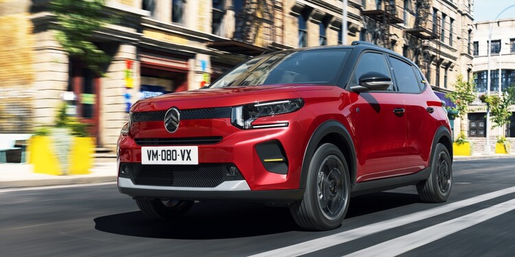 Perfil del Citroën C3 rojo en movimiento, integrado perfectamente en el entorno urbano Perfil del Citroën C3 rojo en movimiento, integrado perfectamente en el entorno urbano