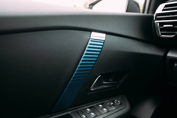 Adorno azul en puerta interior del Citroën C4 X, estilo moderno. Adorno azul en puerta interior del Citroën C4 X, estilo moderno.