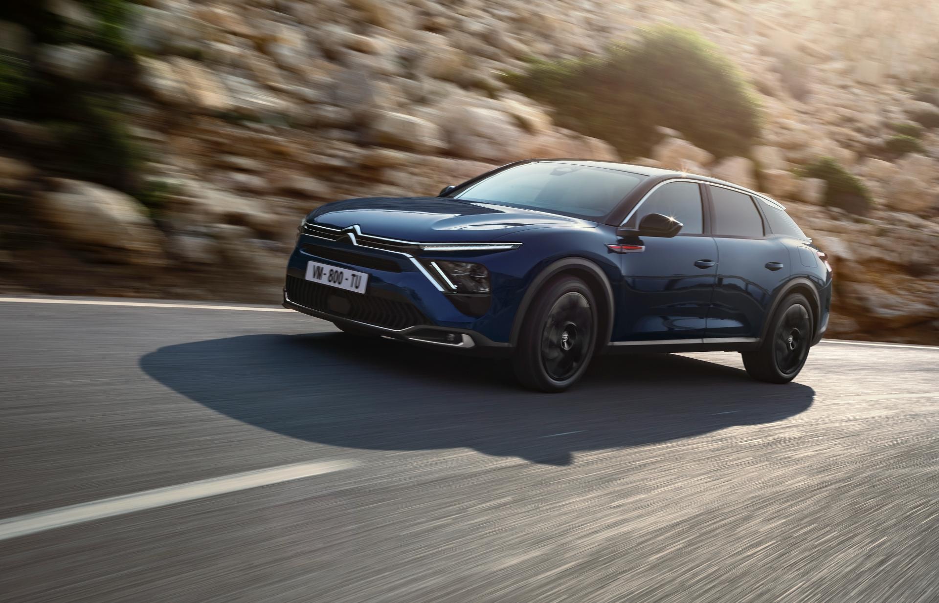 Toma en acción que enfatiza las proporciones y dinamismo del C5 X híbrido.