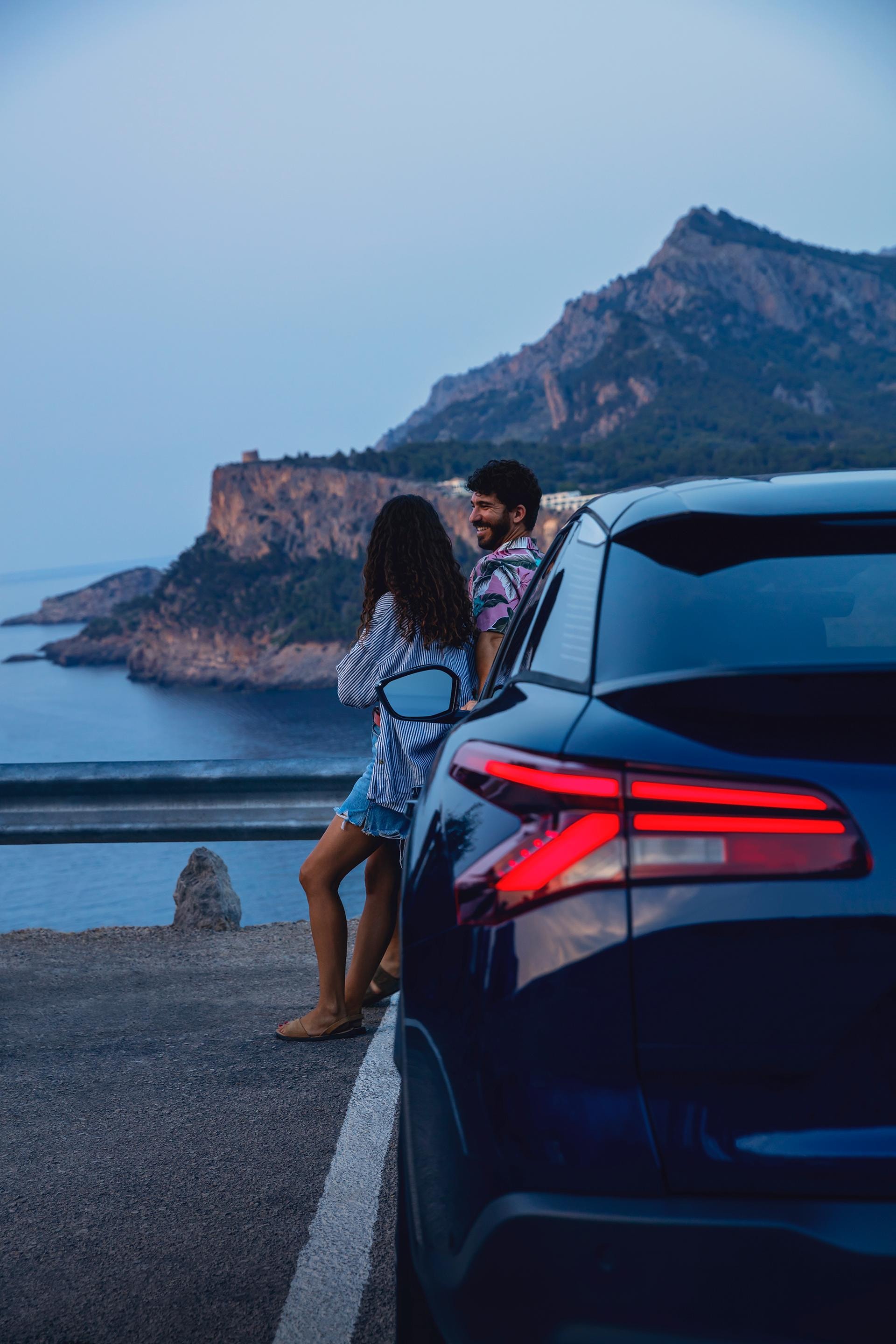 Toma trasera del vehículo con pareja, resaltando su diseño y contexto.