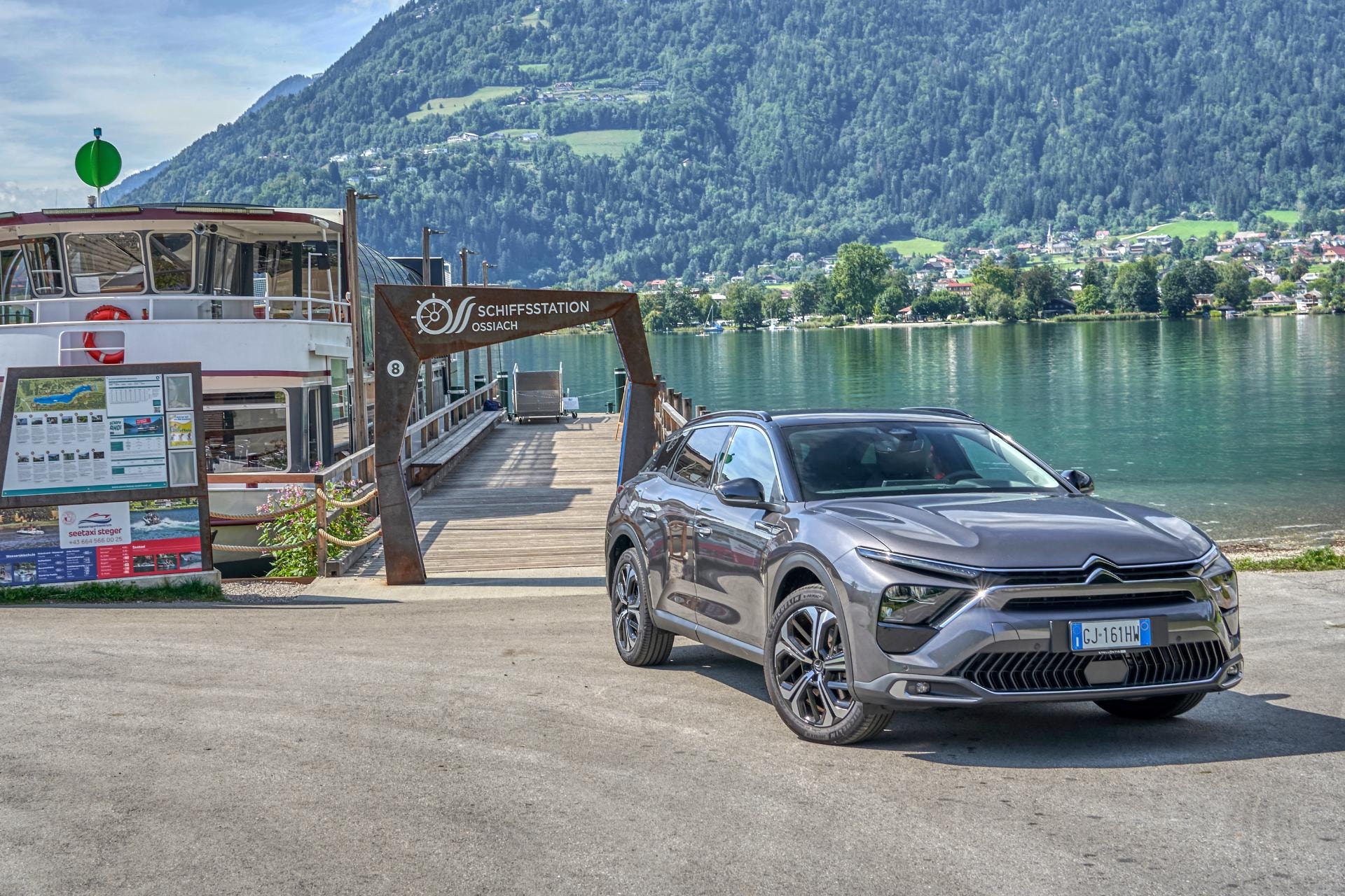 Citroën C5 X híbrido aparcado con vista de un lago, resaltando su diseño moderno.