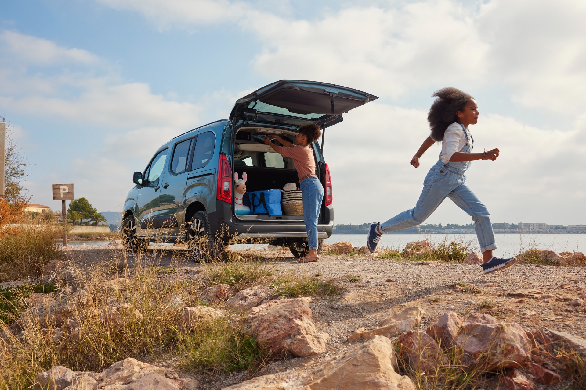 Escena con el Citroën ë-Berlingo y personas, ilustra su uso familiar en exteriores.