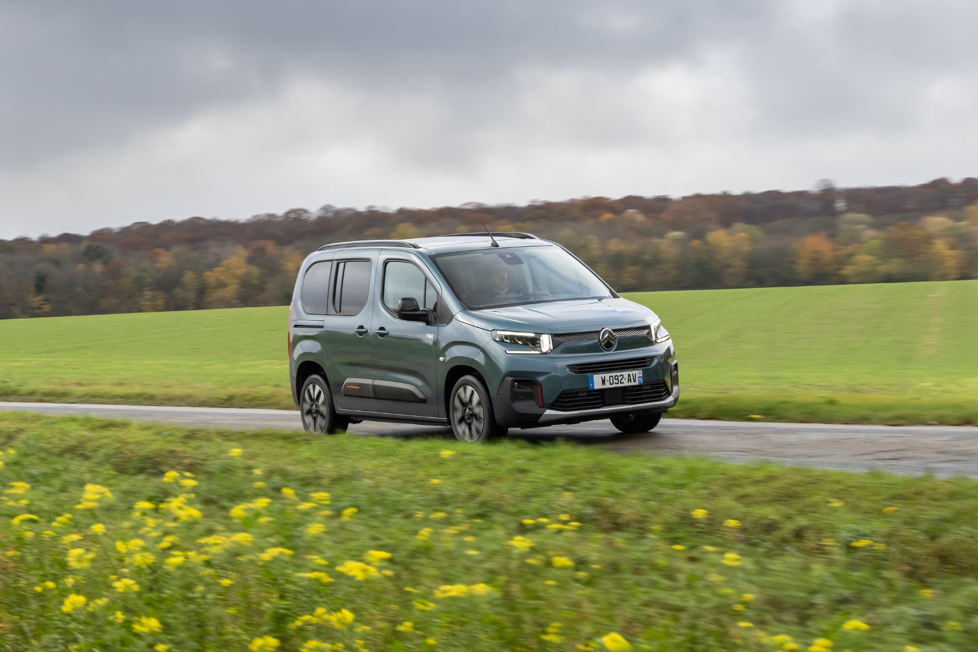 Fotografía dinámica del Citroën ë-Berlingo en movimiento, vista lateral.