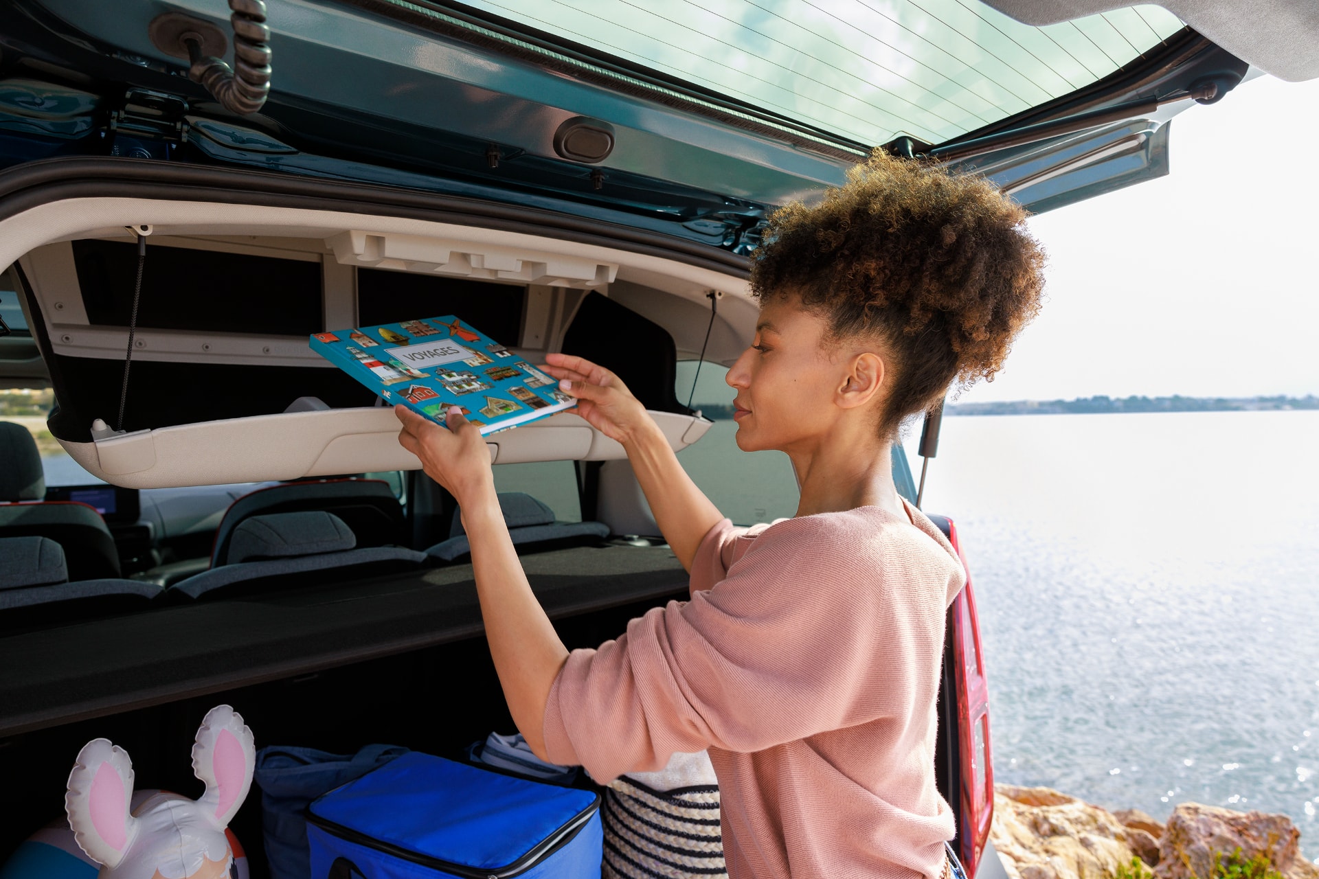 Imagen del maletero del Citroën ë-Berlingo con una persona cargando objetos, subrayando su espacio.