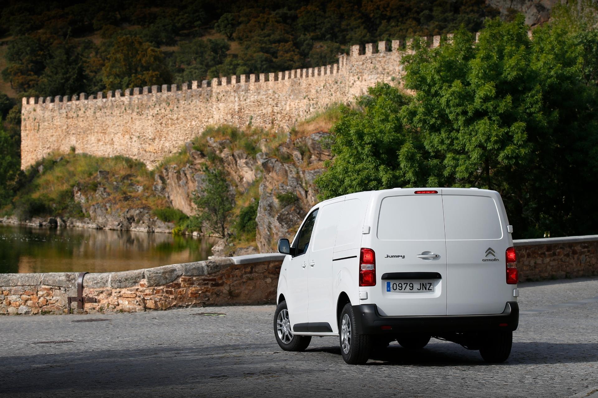 Vista trasera y lateral de la Citroën Jumpy aparcada frente a un muro histórico.
