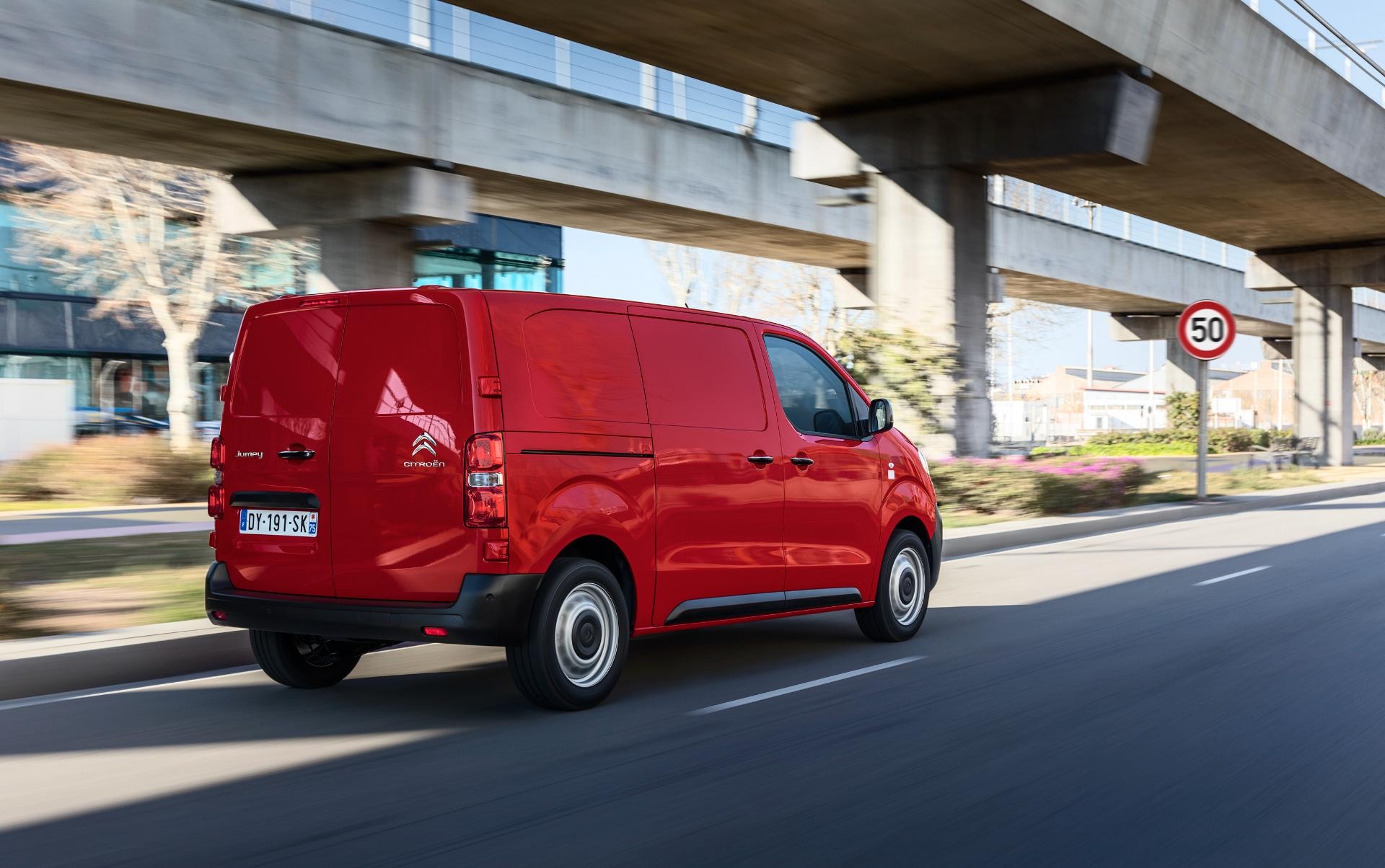 Citroën Jumpy de color rojo en tránsito, exponiendo su lateral y zaga.