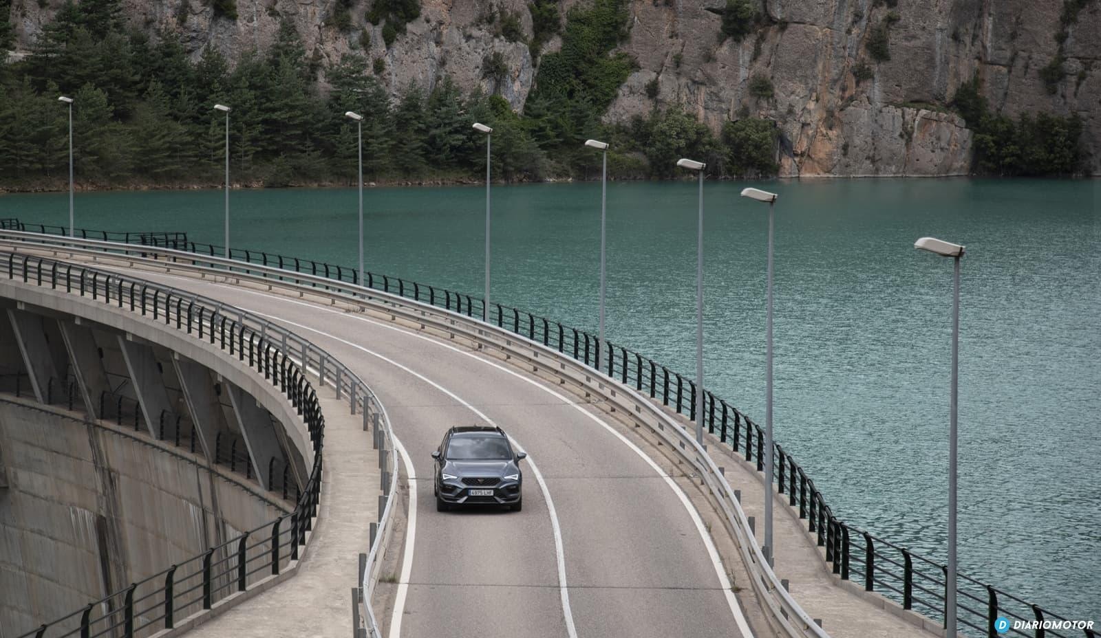 El CUPRA Ateca recorre con elegancia una carretera junto a un lago.
