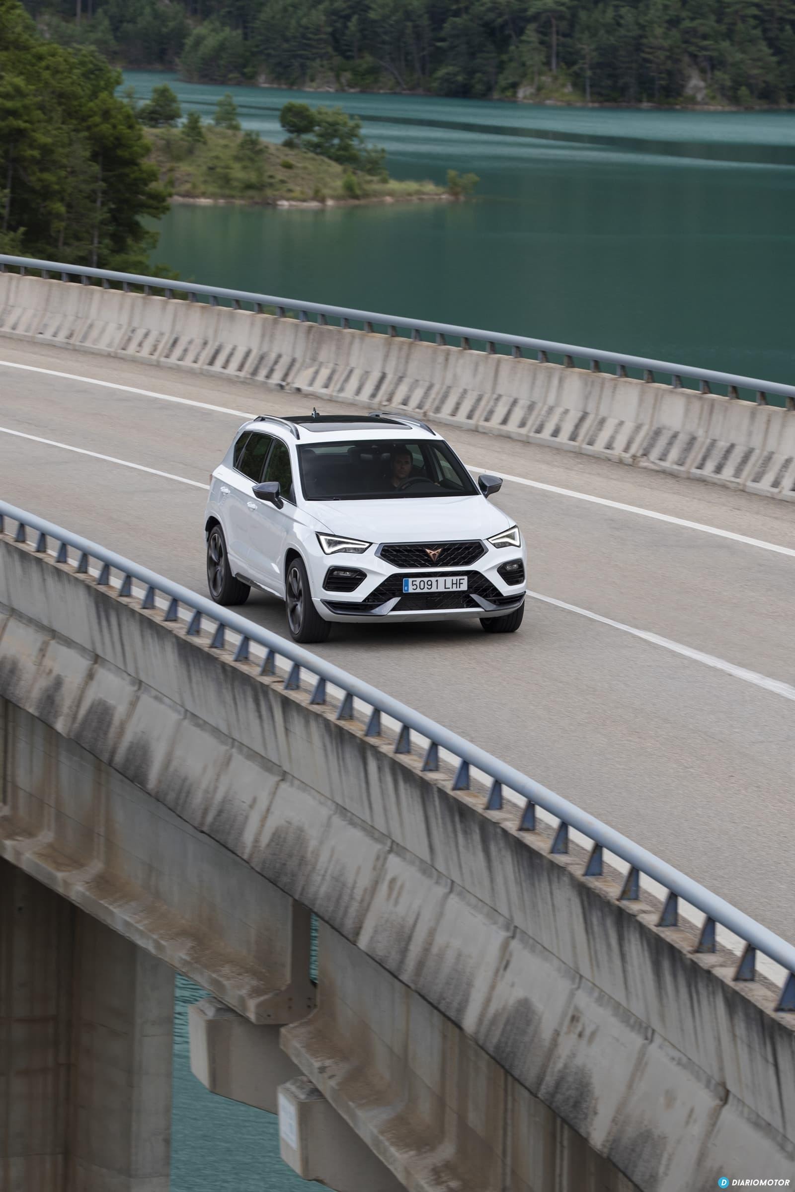 Vista dinámica del Cupra Ateca cruzando un puente, resaltando su diseño frontal y lateral.