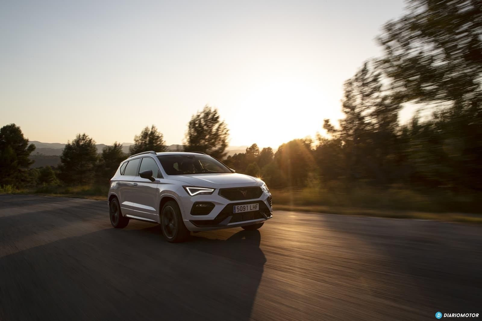 El Cupra Ateca lateralmente capturado en un movimiento fluido bajo la puesta de sol.