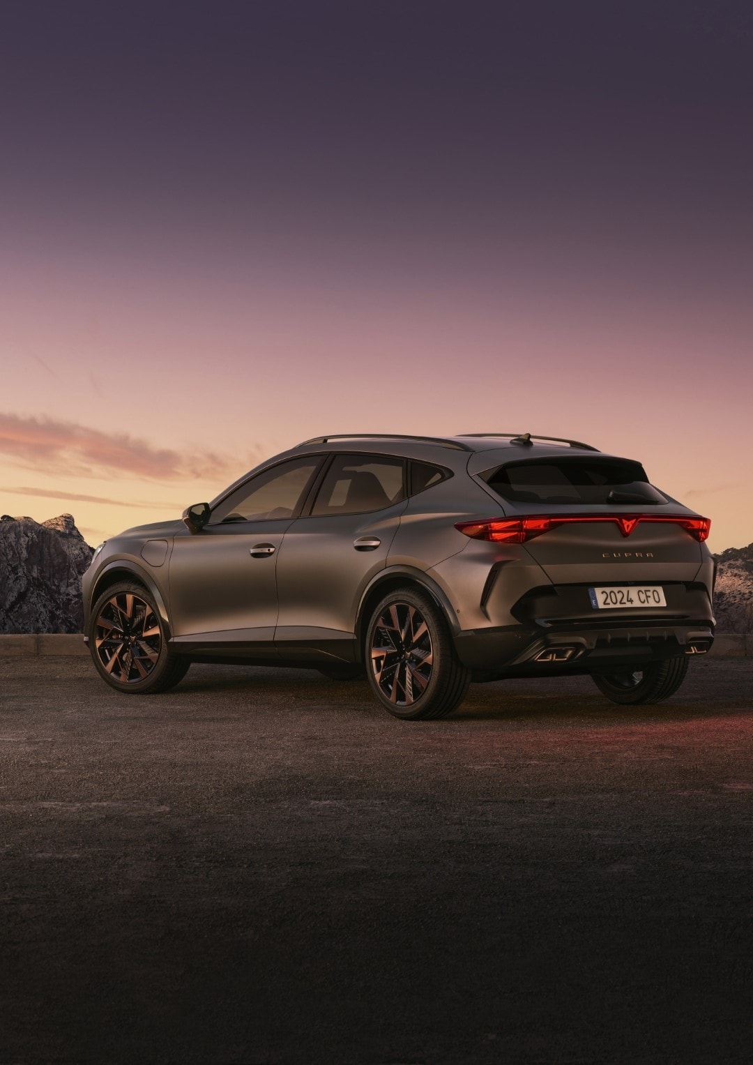 Perspectiva trasera y lateral del Cupra Formentor con una puesta de sol de fondo.