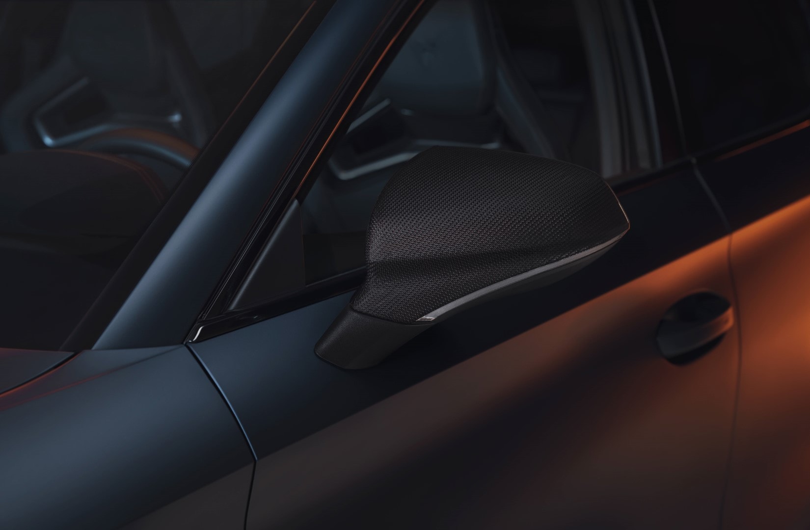 Retrovisor del Cupra León con acabados en fibra de carbono y diseño aerodinámico.