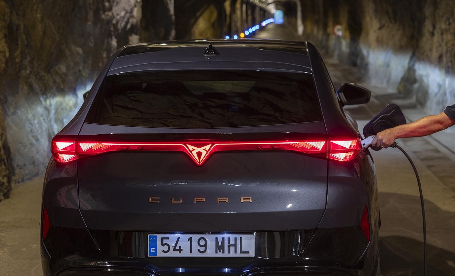 Carga eléctrica del Cupra Tavascan destacando sus luces traseras
