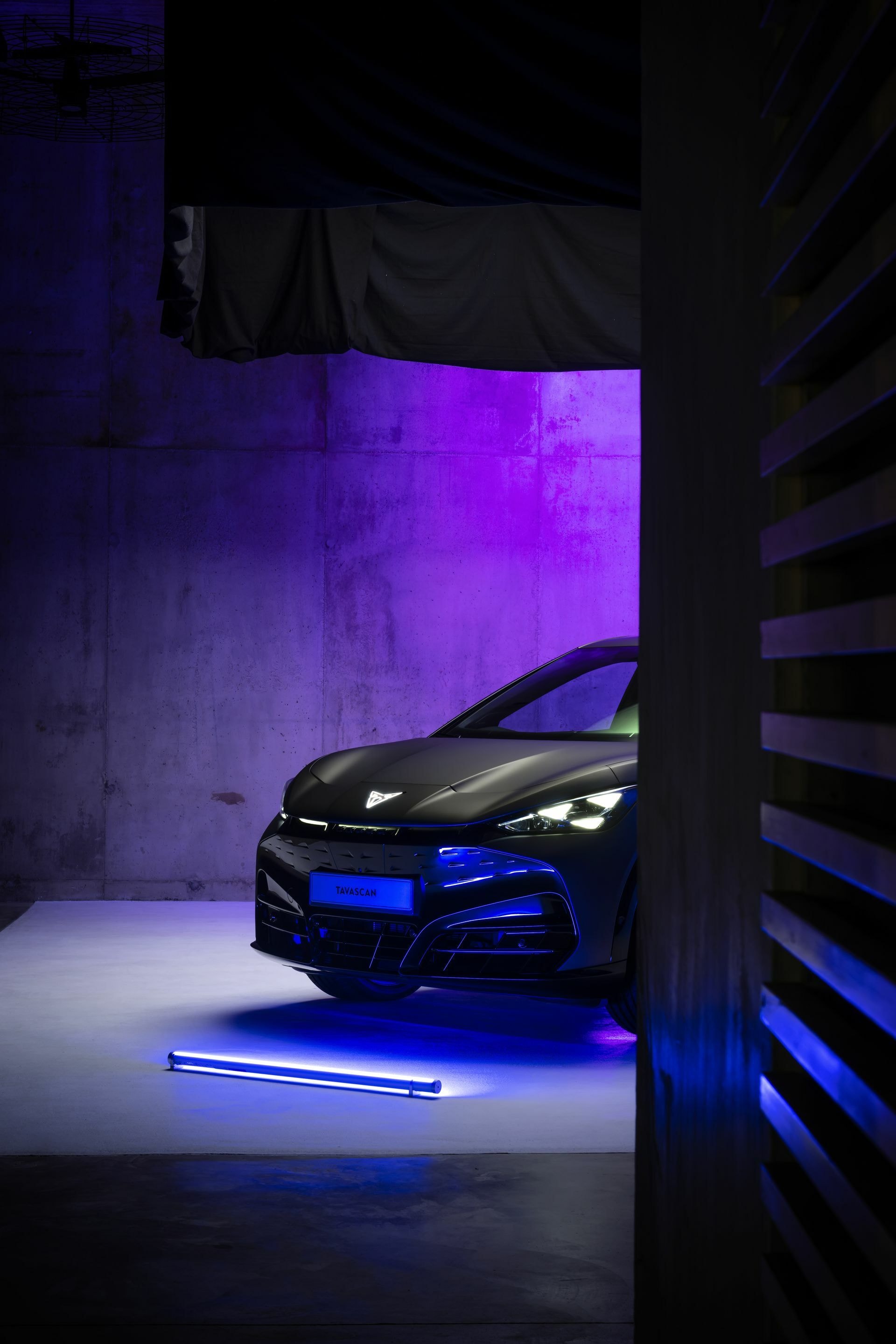 El frontal del Cupra Tavascan emerge de la oscuridad con una iluminación dinámica.