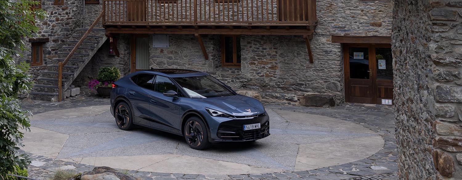 Cupra Tavascan en entorno rústico, destacando su diseño y presencia.