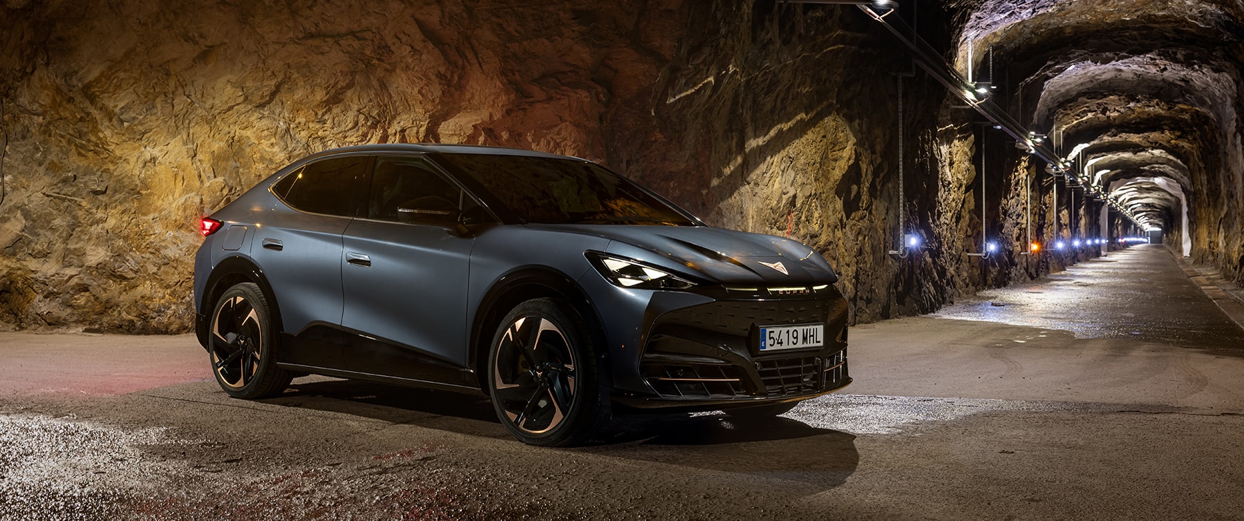 Perfil lateral del Cupra Tavascan en un entorno de túnel iluminado