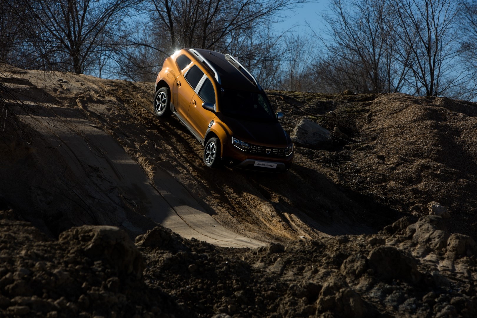 Enfoque lateral del Dacia Duster bajo la luz del sol, subrayando su forma y diseño.