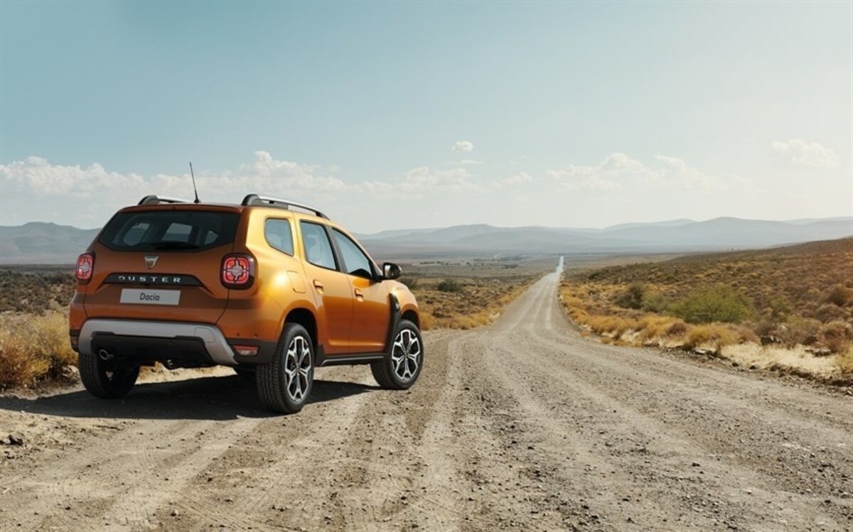 Perfil trasero del Dacia Duster enfrentándose a caminos desérticos largos y polvorientos. Perfil trasero del Dacia Duster enfrentándose a caminos desérticos largos y polvorientos.