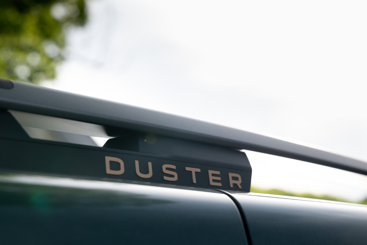 Enfoque en el logo 'DUSTER' sobre el alerón trasero del vehículo. Enfoque en el logo 'DUSTER' sobre el alerón trasero del vehículo.